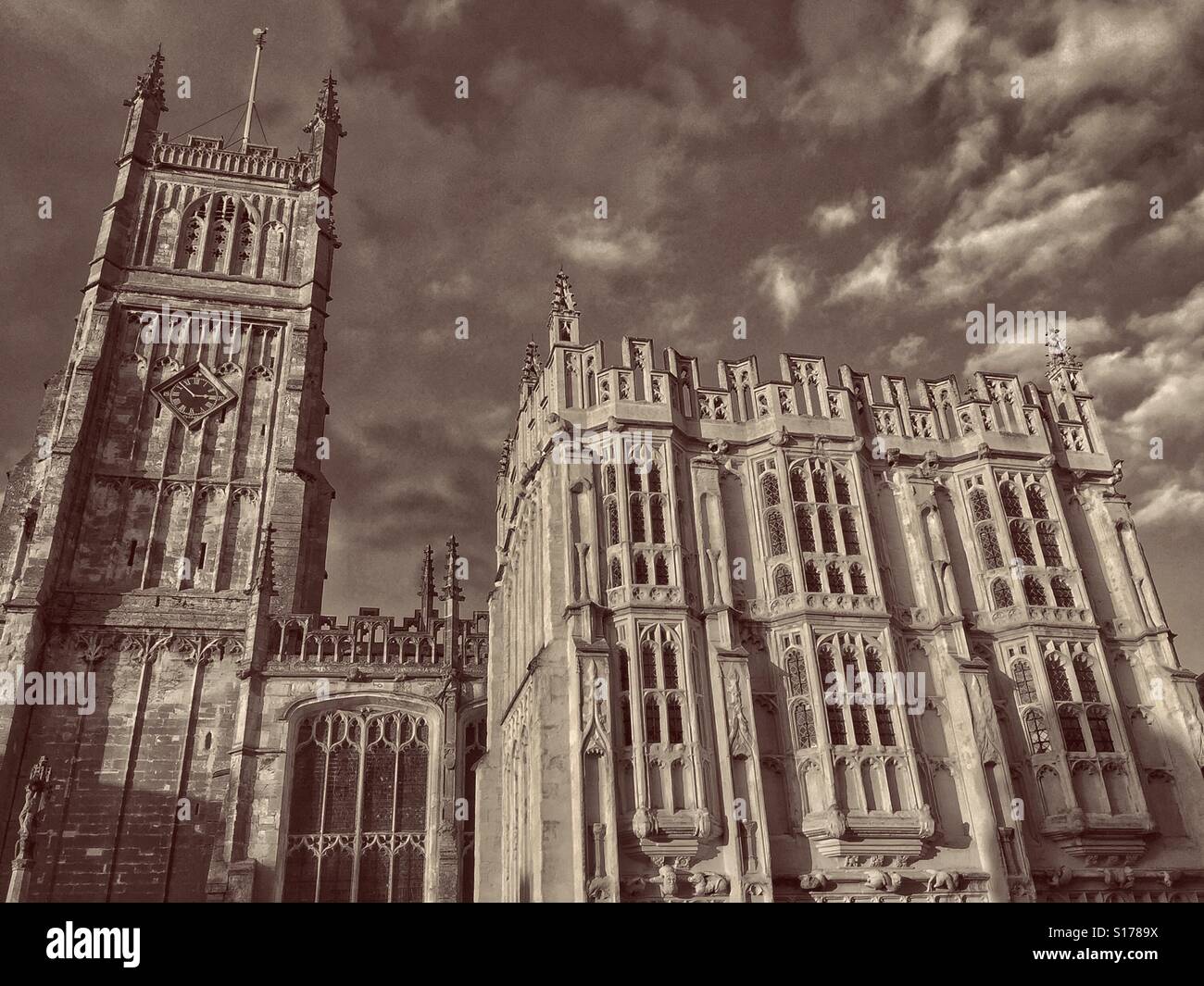 Una vista esterna di San Giovanni Battista a Cirencester, Gloucestershire, Inghilterra. A sinistra si trova la torre quattrocentesca. Sulla destra è il grande portico sud. Credito foto - © COLIN HOSKINS. Foto Stock