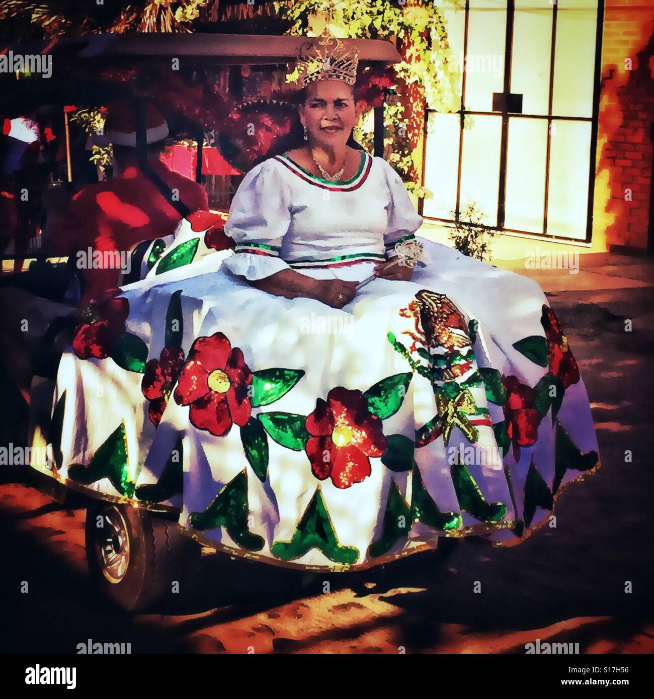 Un regal donna in una corona e bel vestito con l'emblema della bandiera messicana scorre in un veicolo durante una parata natalizia di Nayarit, Messico. Foto Stock