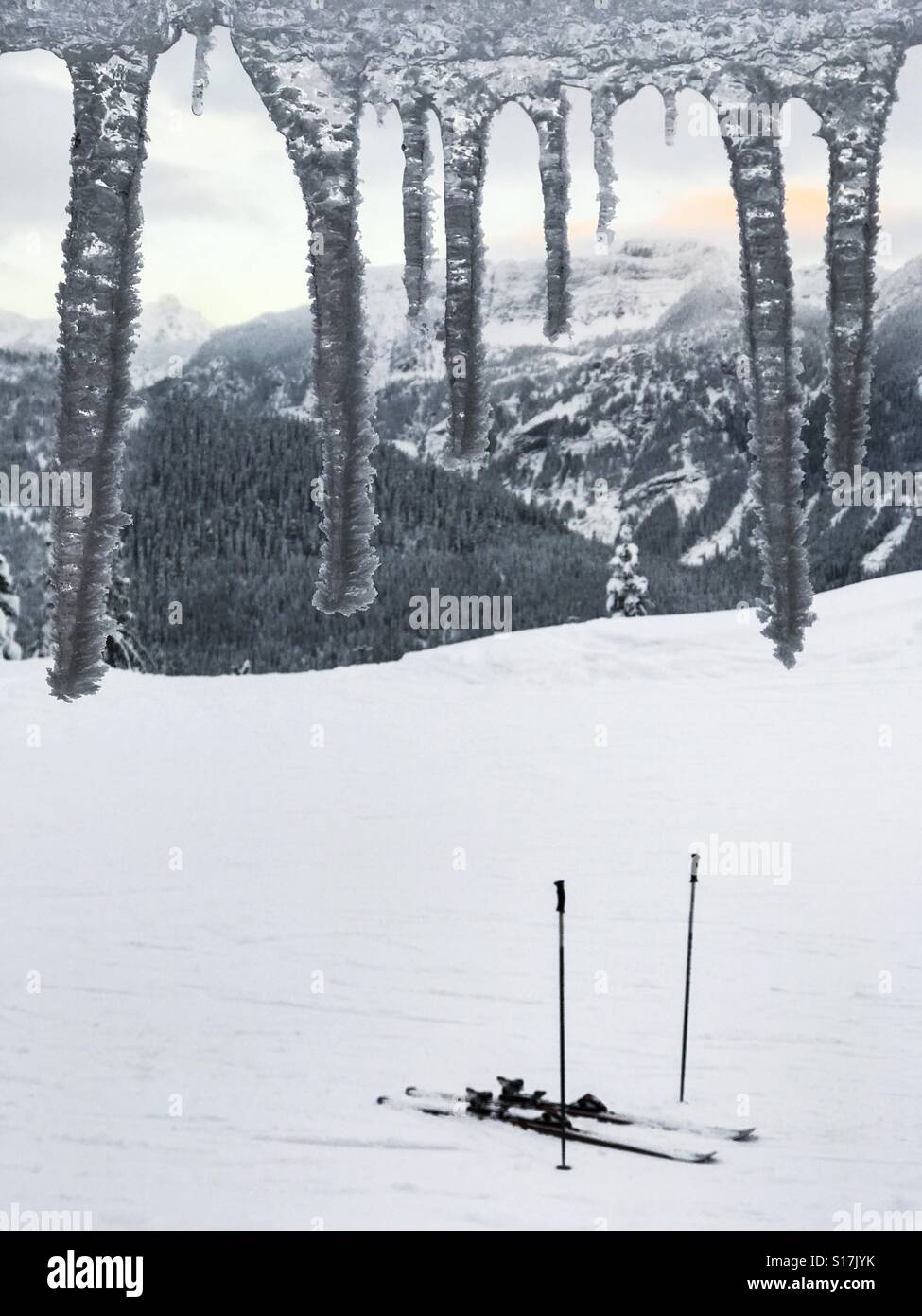 Guardando fuori sulle montagne in un'area sciistica attraverso ghiaccioli Foto Stock