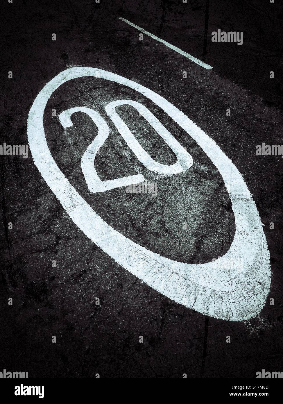 Il numero venti è dipinta su una strada asfaltata per informare gli automobilisti della zona sono in ha un massimo di 20 miglia per ora il limite massimo di velocità. Credito foto - © COLIN HOSKINS. - Immagine stock catturata con smartphone