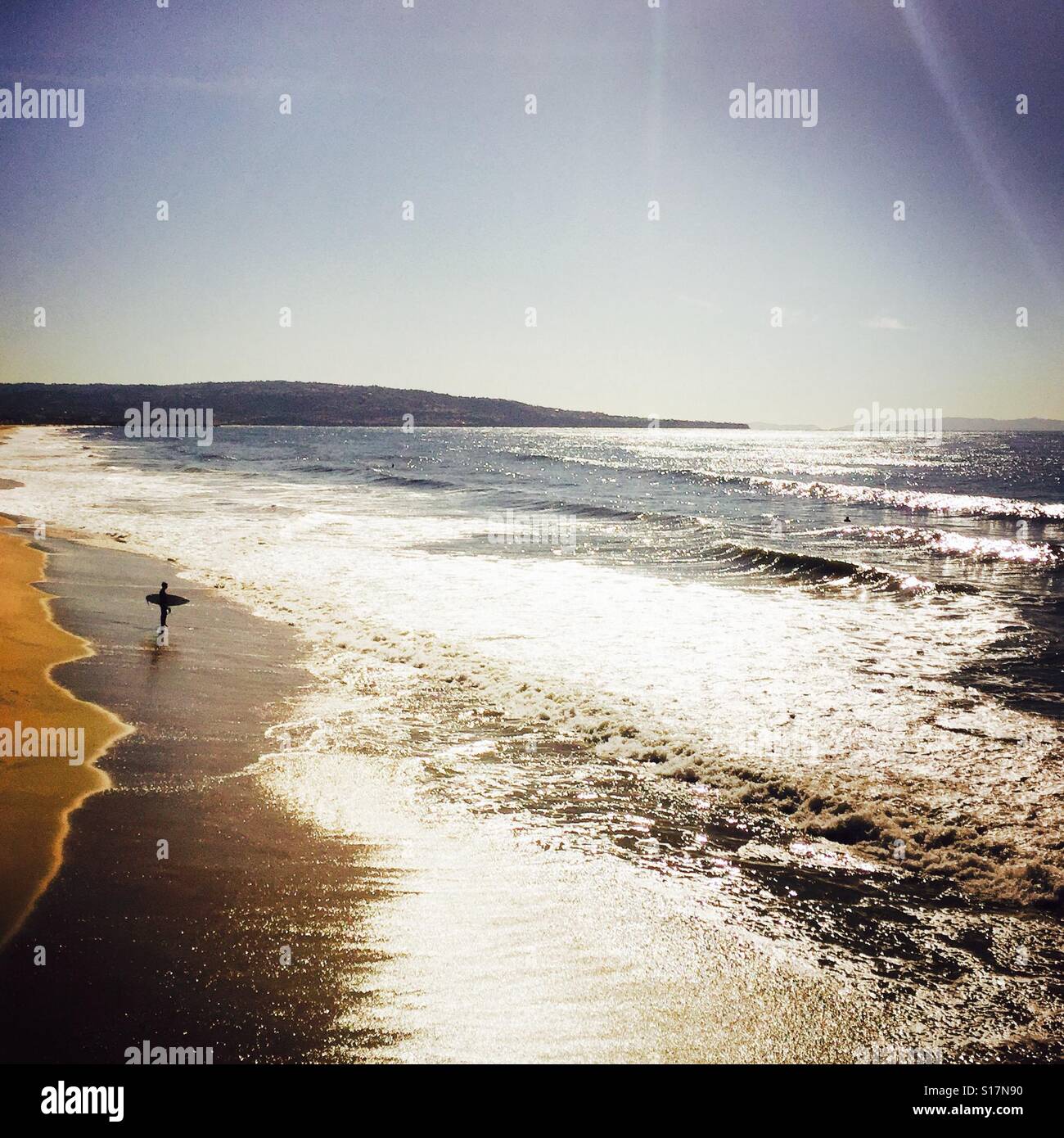 Surfer permanente sulla spiaggia circa per surfing. Manhattan Beach, California USA. Foto Stock