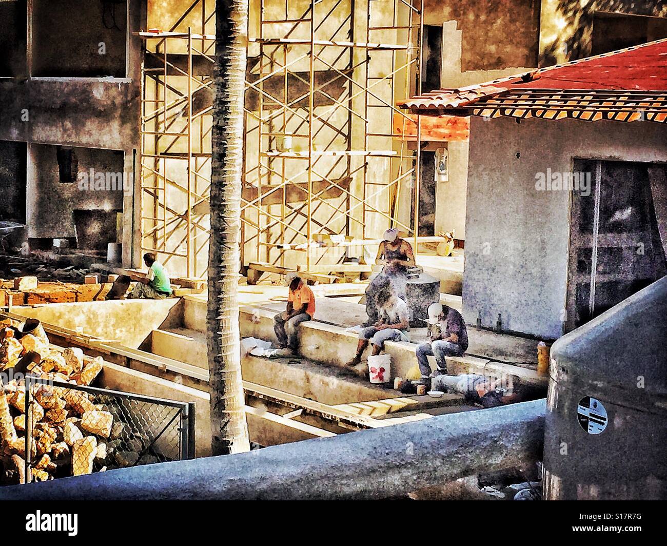 Sito in costruzione con lavoratori su una pausa con i loro telefoni cellulari. Foto Stock