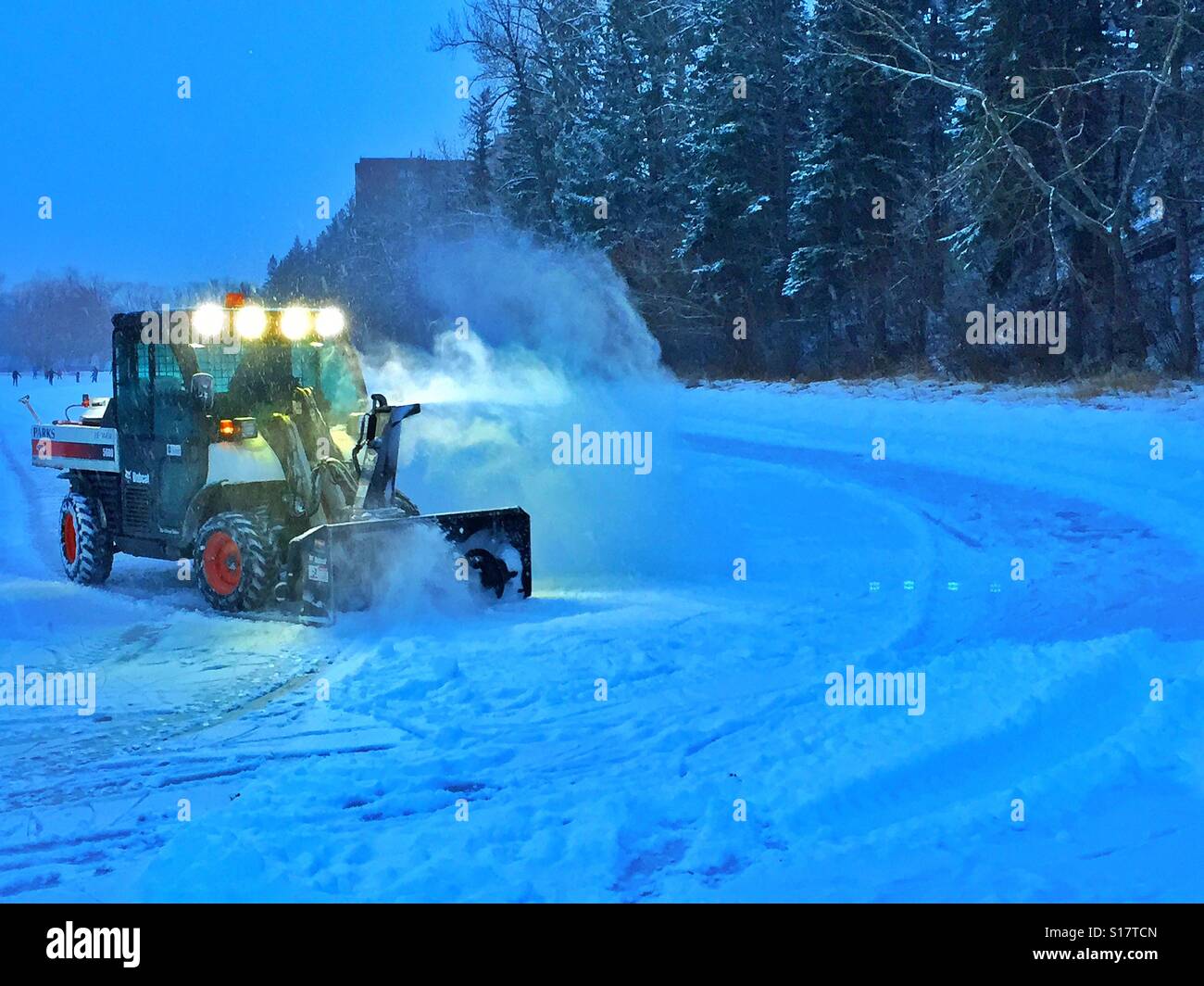 Lo sgombero neve per la famiglia il pattinaggio su Bowness Laguna, Calgary, Alberta, Canada - Immagine stock catturata con smartphone