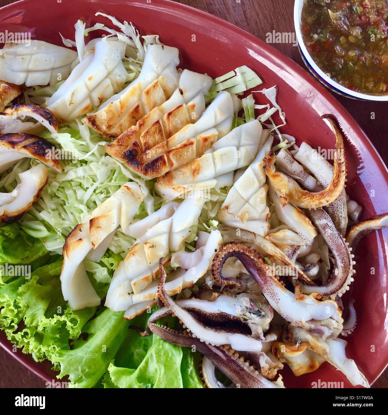Stile Tailandese Calamari Grigliati serviti con peperoncino piccante salsa, Samut Songkhram provincia, Thailandia Foto Stock