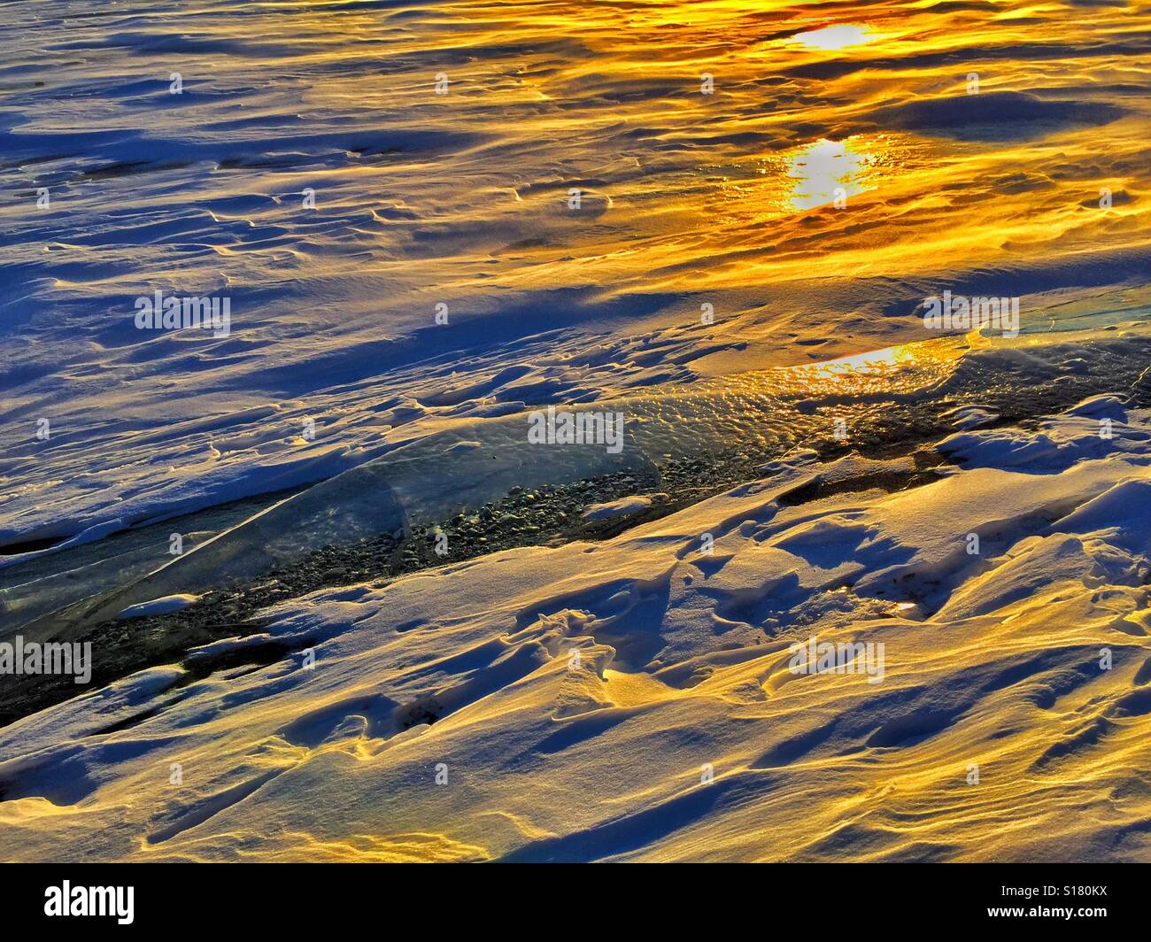 Tempesta di neve, ghiaccio e sole di setting riflessione sulla diga di Glenmore a Calgary, Alberta, Canada - Immagine stock catturata con smartphone