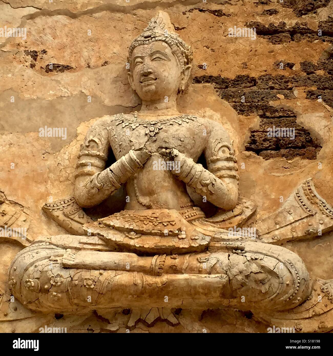 Il Wat Jed Yod è un attraente Lanna era complesso tempio nella periferia della città di Chiang Mai che contiene alcuni molto esclusiva architettura. Una divinità predisposto sulla parete del tempio, Thailandia. Foto Stock