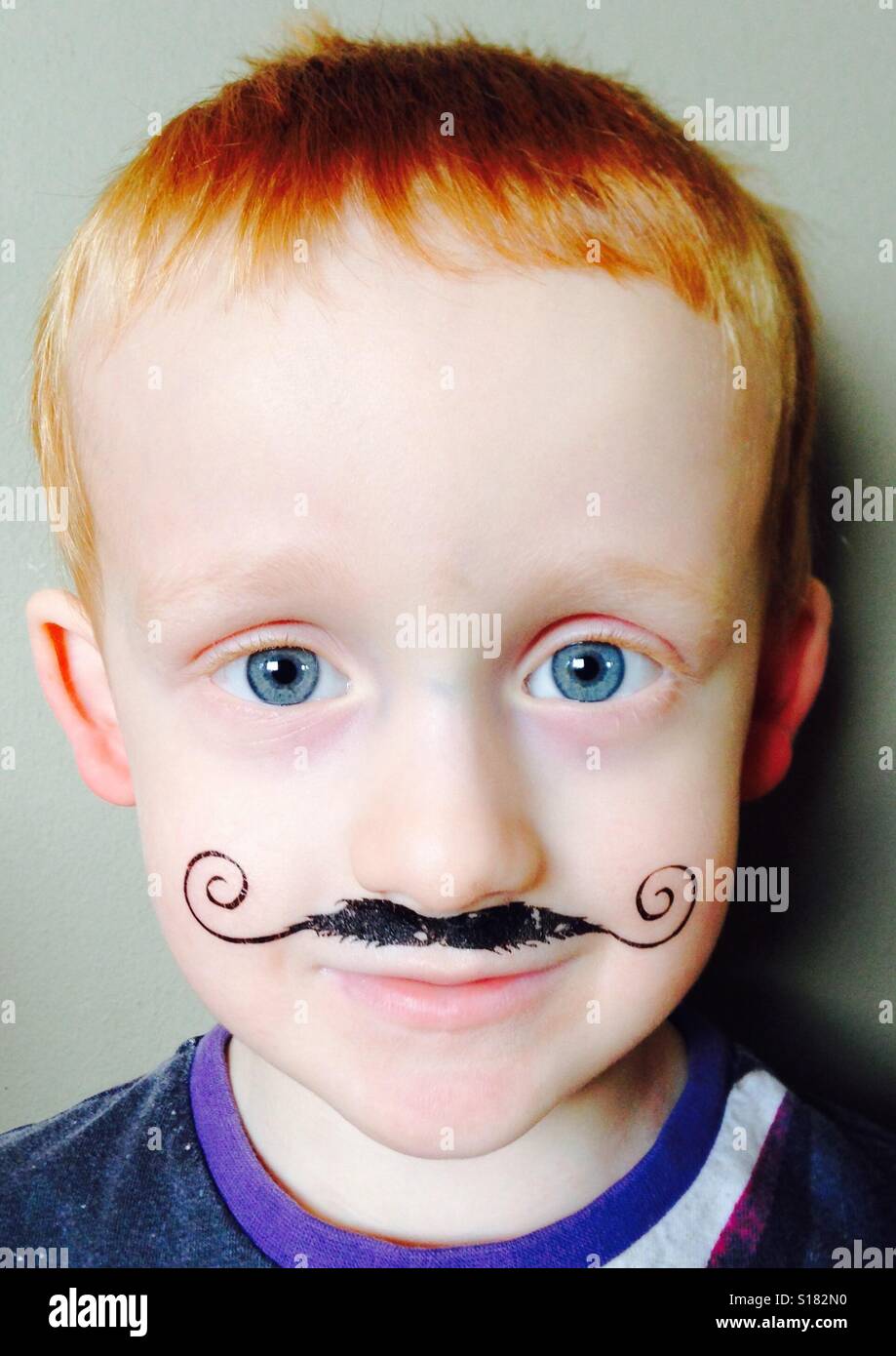 Dai capelli rossi, blu eyed boy con una parentesi disegnato su baffi Foto Stock