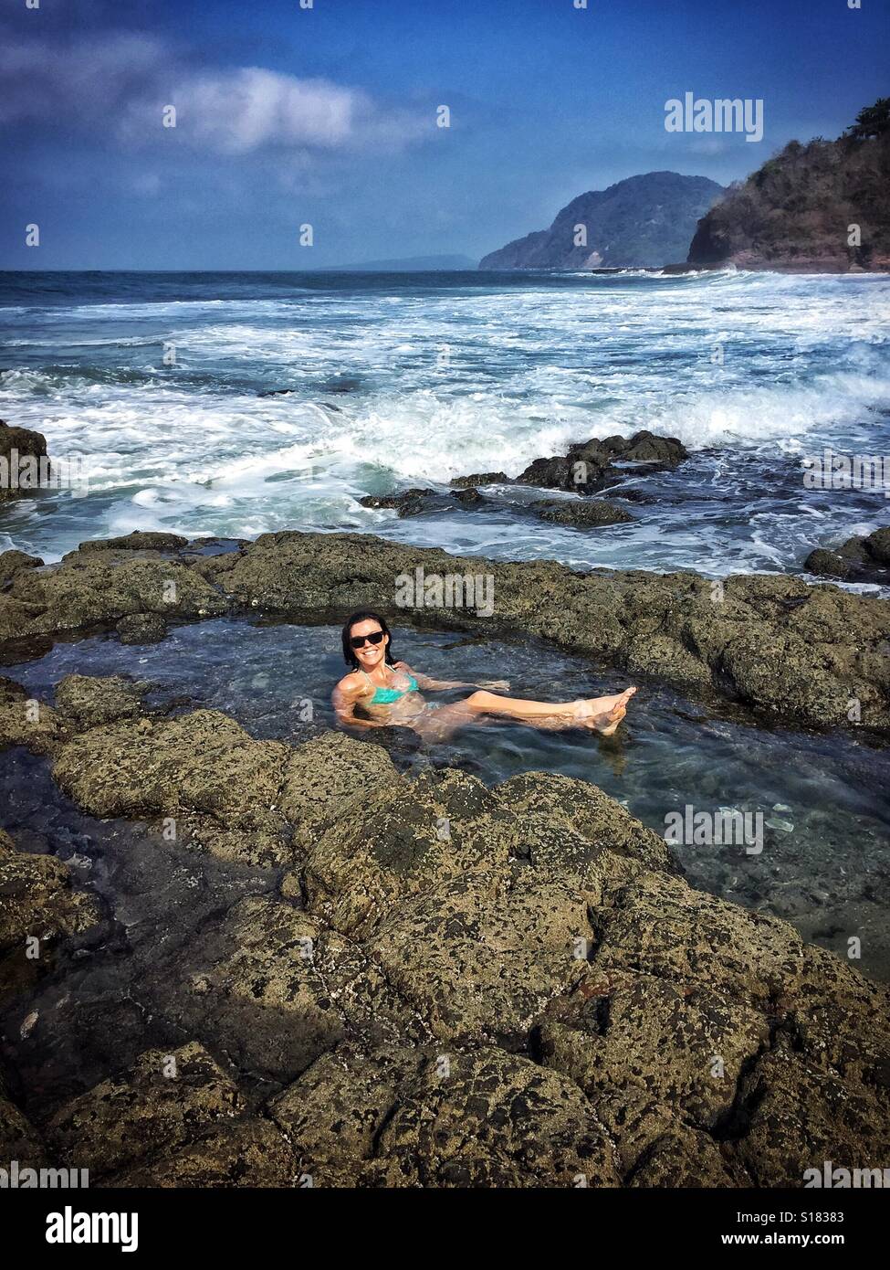 Una donna si rilassa in un pool di marea su una spiaggia isolata in Nayarit, Messico. Foto Stock