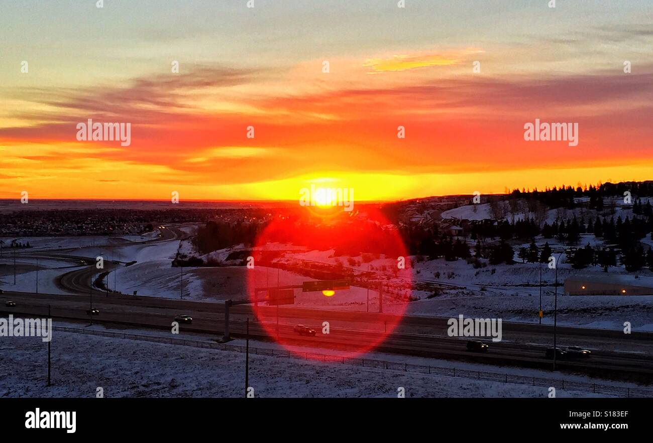 La mattina presto alba sulla città di Calgary con lens flare e principale arteria di traffico Foto Stock
