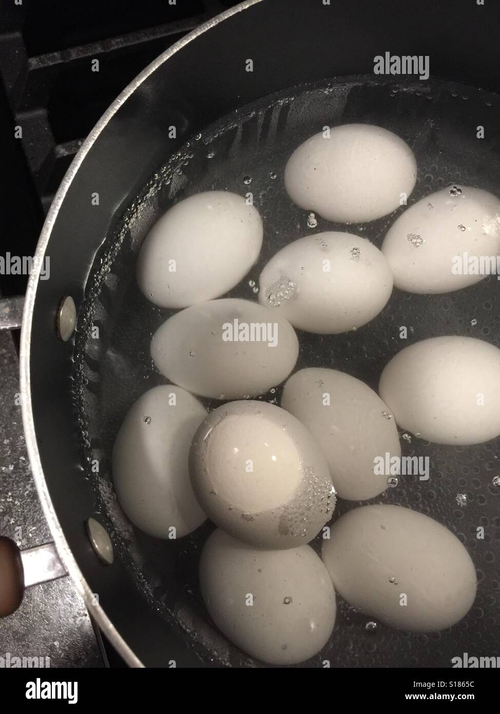 Bollire le uova in una pentola di acqua Foto Stock