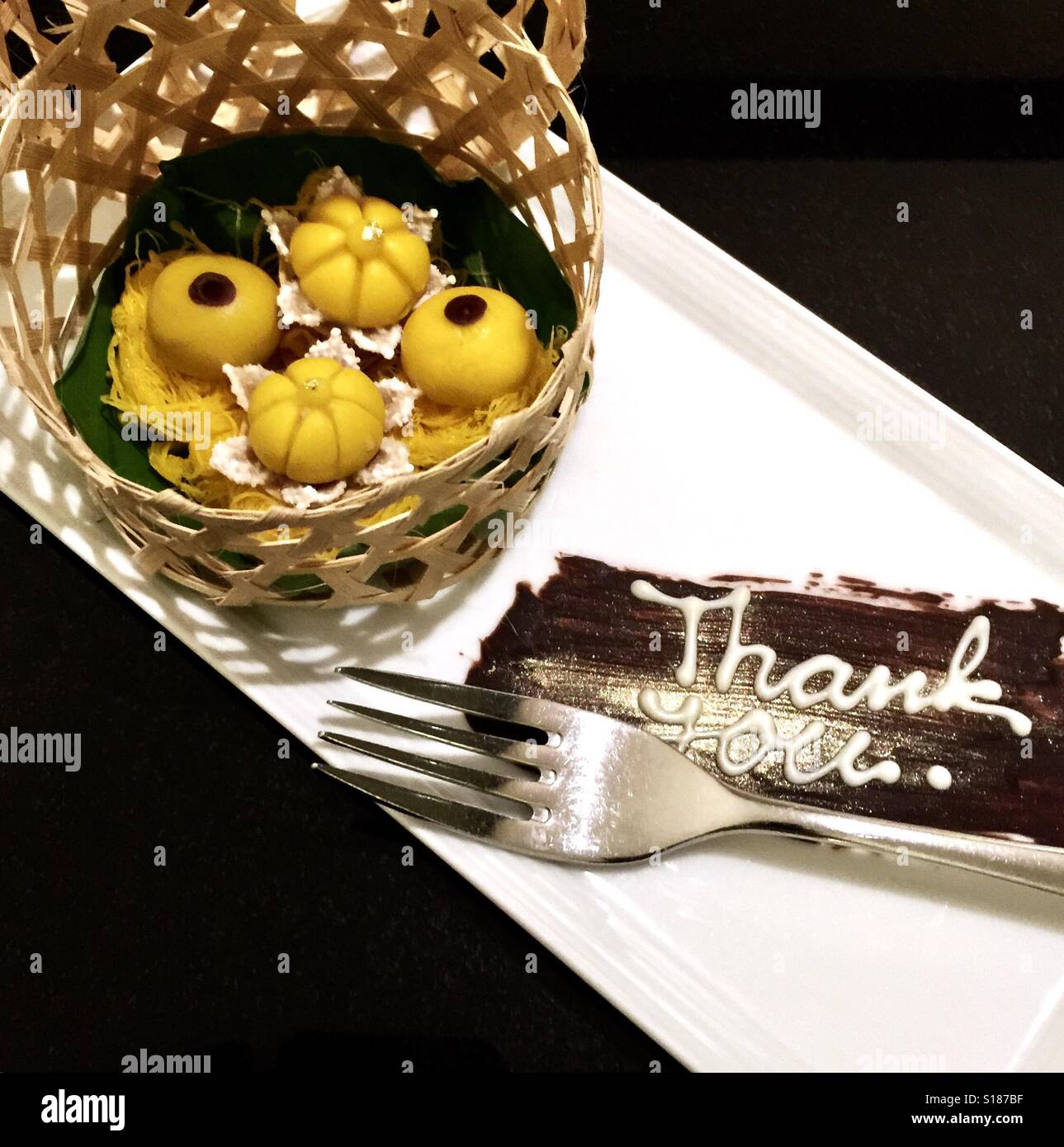 I dessert Thai in un cestello posto su una piastra con una nota di ringraziamento Foto Stock
