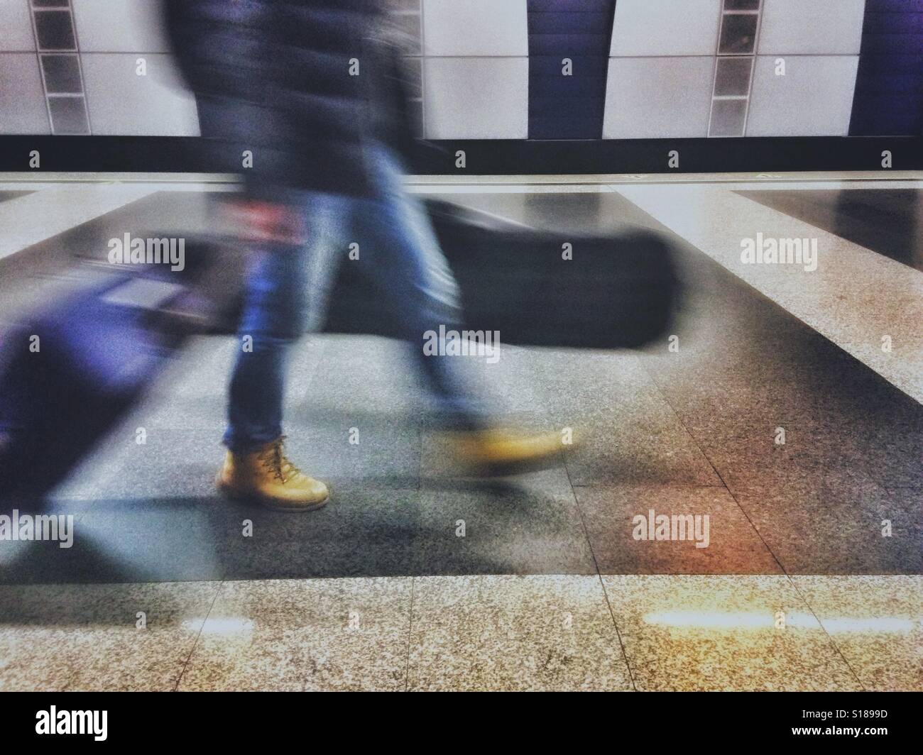 La sfocatura in movimento di una persona a piedi con le valigie Foto Stock
