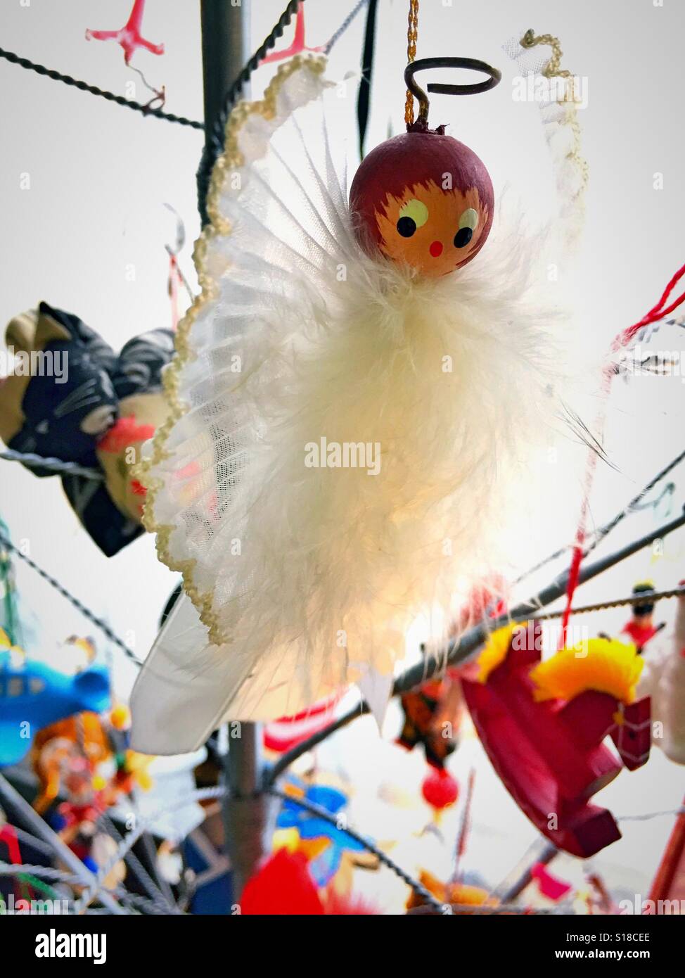 Angelo in legno adornano ornamento con piume in albero di Natale, STATI UNITI D'AMERICA - Immagine stock catturata con smartphone