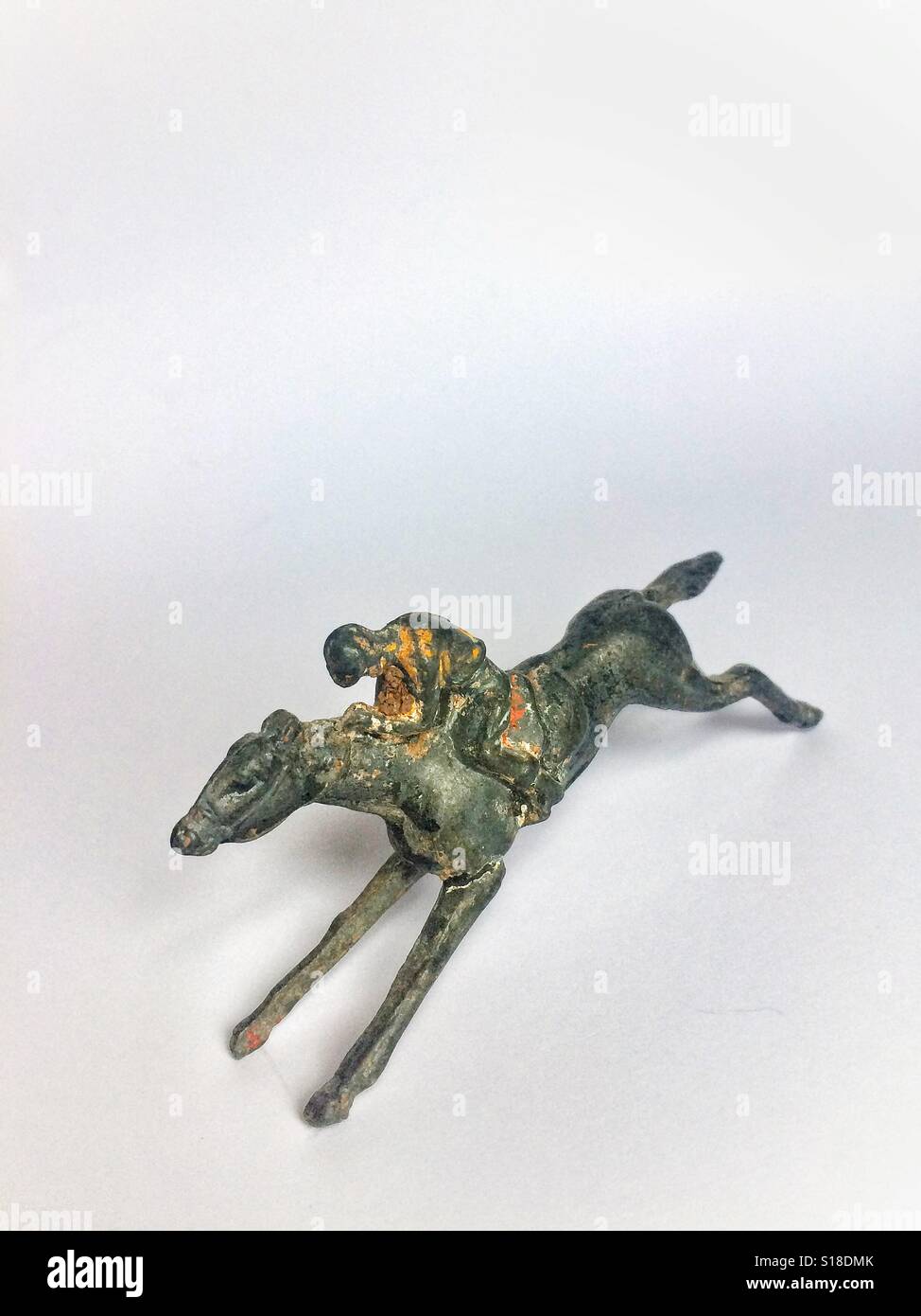 Un giocattolo cavallo da corsa e jockey su sfondo bianco - Immagine stock catturata con smartphone