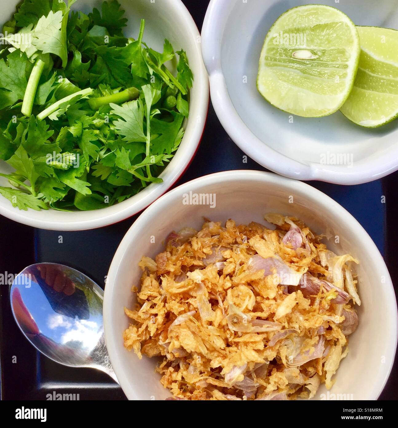 Riso tailandese porridge condimenti - frittura di aglio, sedano cinese e thailandese lime Foto Stock