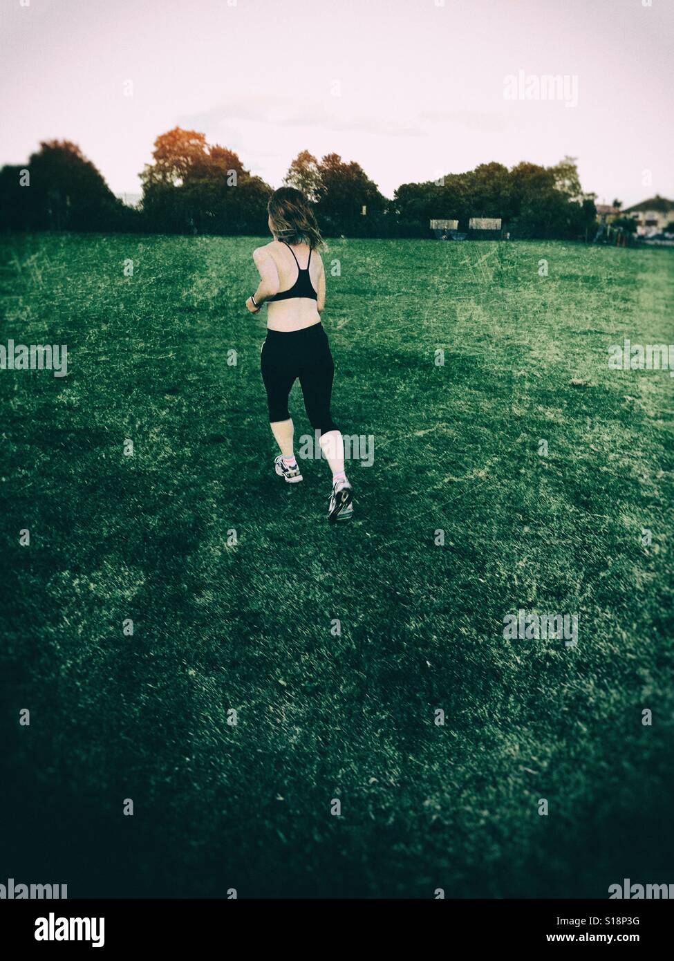 La donna in esecuzione in un parco - Immagine stock catturata con smartphone