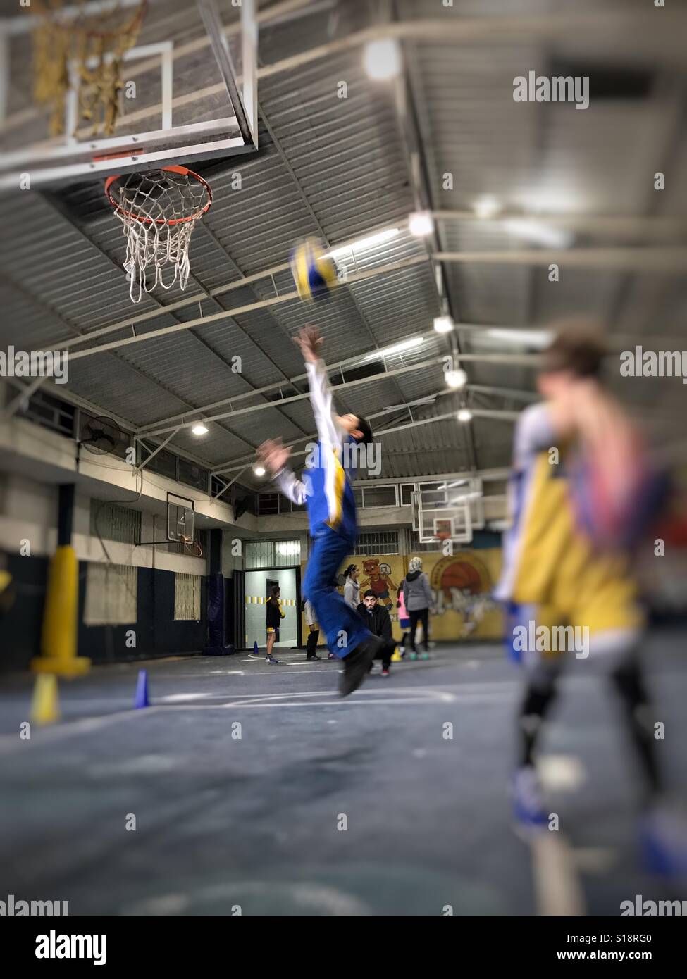 Un ragazzo di sport di eseguire un layup di pallacanestro - Immagine stock catturata con smartphone