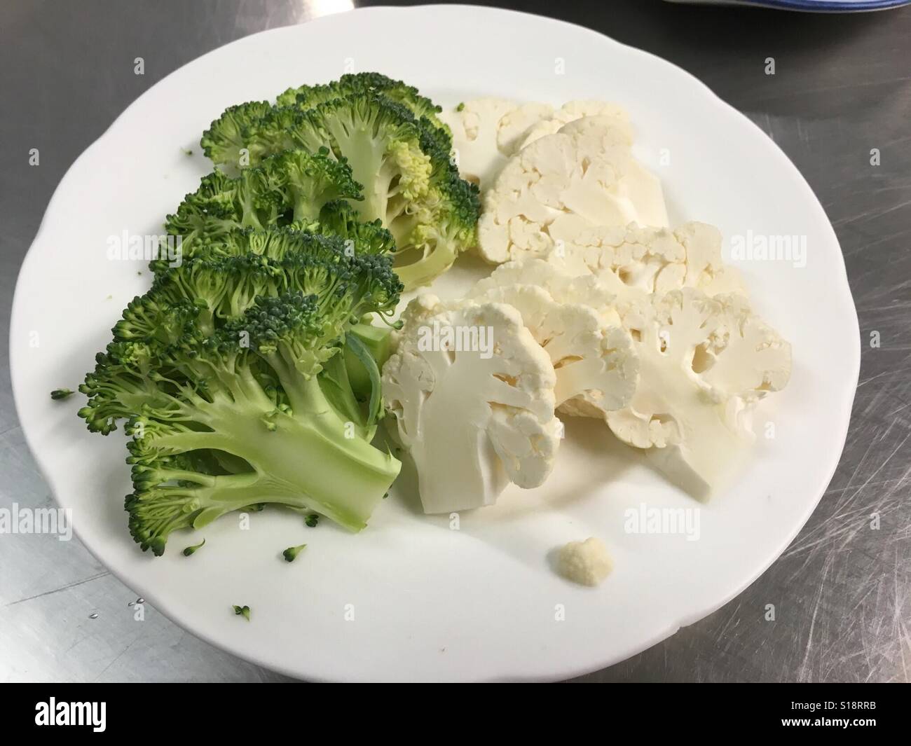 Broccoli e cavolfiore tagliato su una piastra bianca. - Immagine stock catturata con smartphone
