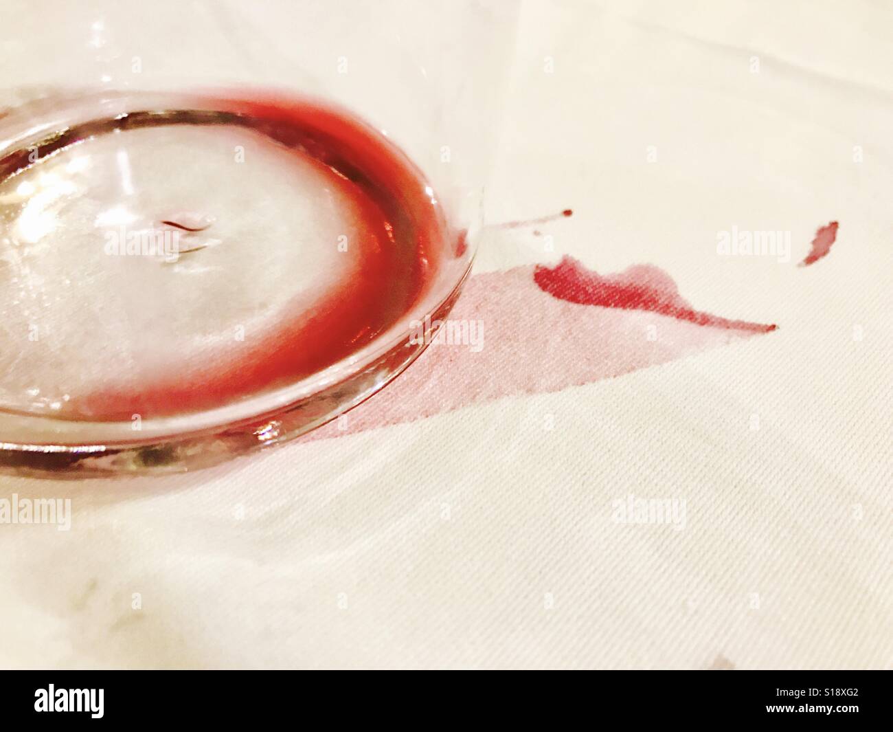 Svuotare un bicchiere di vino rosso e la macchia di vino sulla tovaglia  Foto stock - Alamy