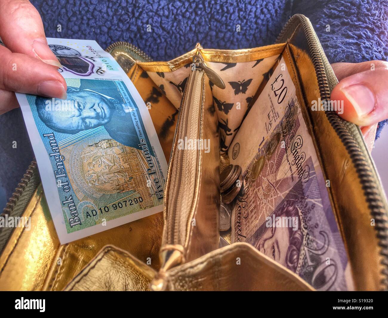 Prendendo a 5 sterline in borsa - Immagine stock catturata con smartphone