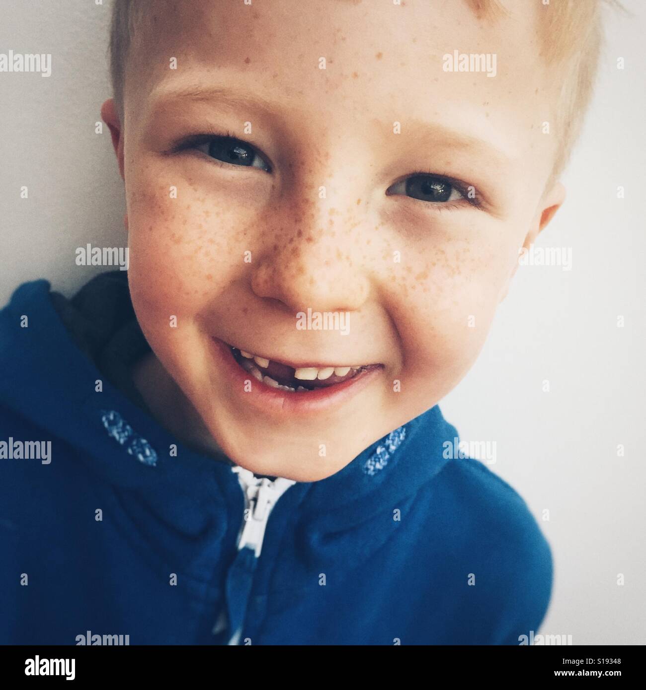 Sorridente di sette anni ragazzo con dente mancante Foto Stock