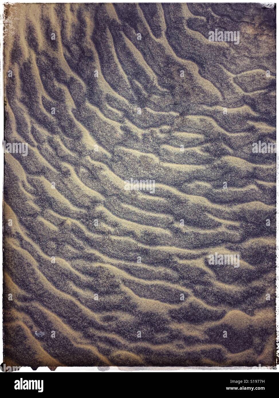 Acqua si forma sulla sabbia. - Immagine stock catturata con smartphone