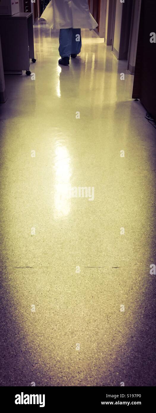 Corridoio molto lungo in un ambiente medico. Un cappotto da laboratorio, simbolo di molte professioni, entra nel corridoio in cima, Ontario, Canada. Concetti: Lungo cammino avanti, ricerca, movimento, fretta. - Immagine stock catturata con smartphone