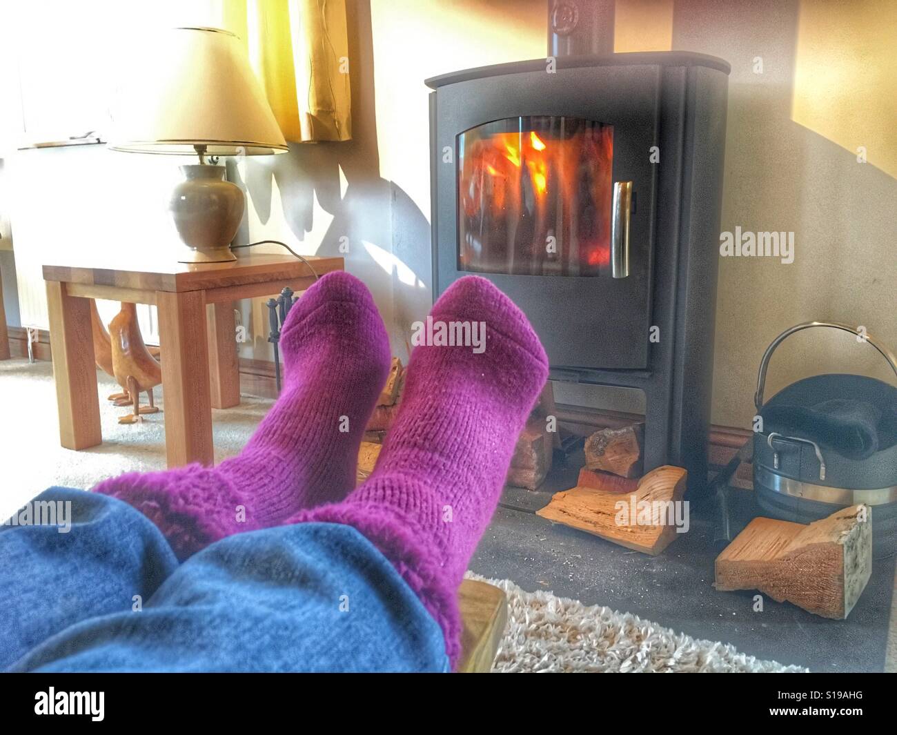 Mantenendo calda in inverno, piedi davanti al camino - Immagine stock catturata con smartphone