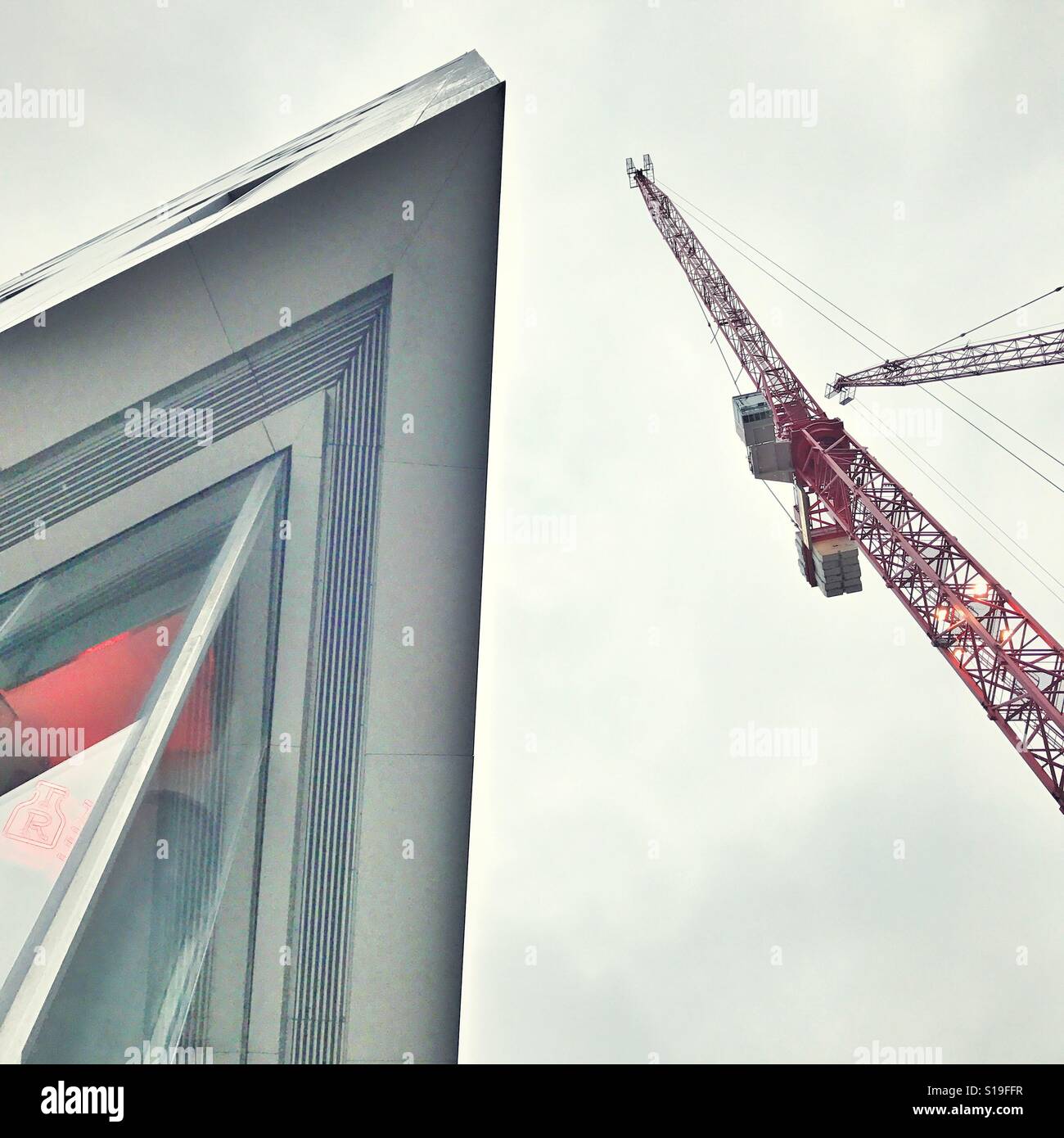 Angolo della punta di un edificio e una gru da cantiere Foto Stock