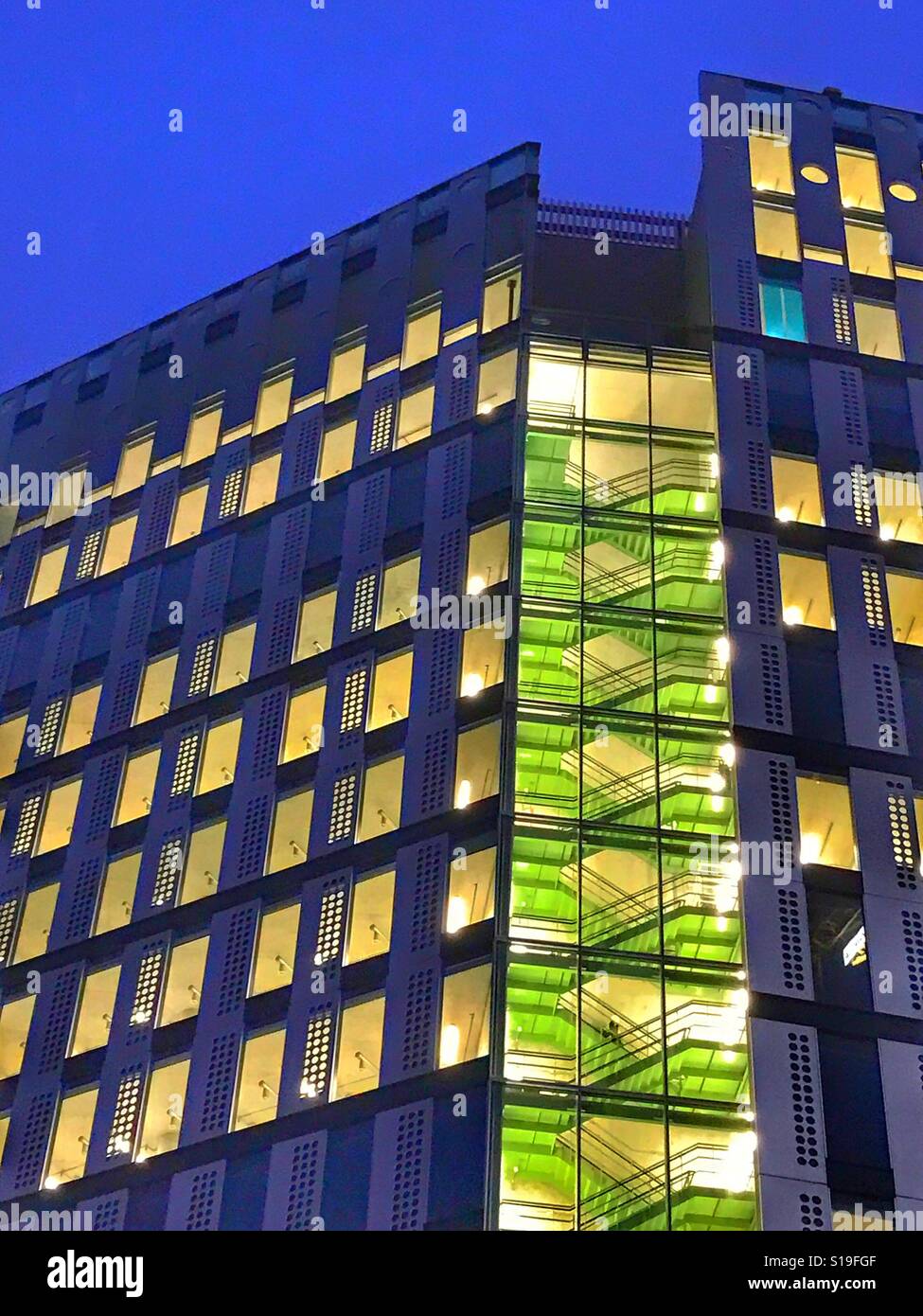 Un nuovo blocco ufficio illuminato contro il cielo di sera - Immagine stock catturata con smartphone