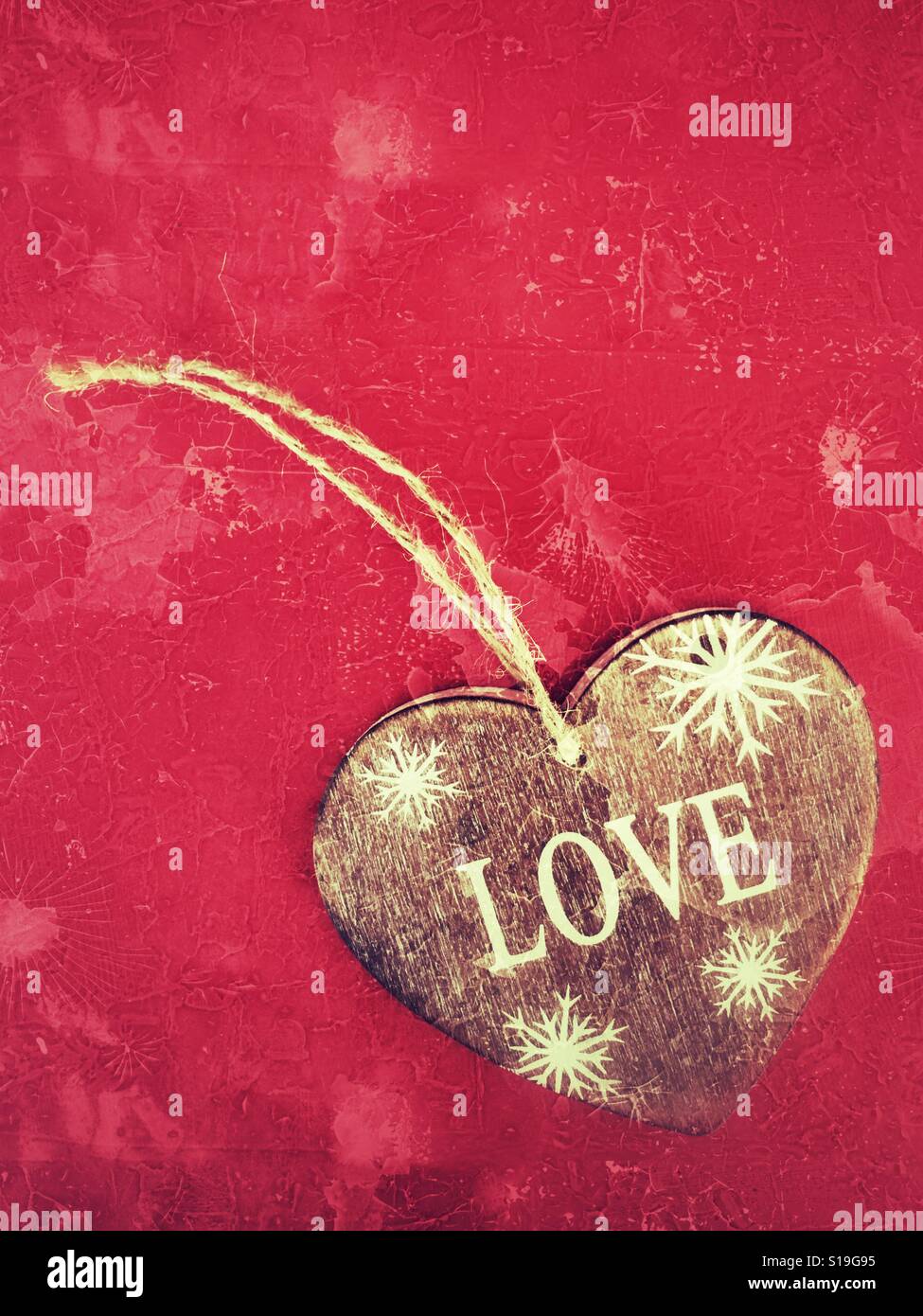 Cuore in legno con la parola amore, isolato su sfondo rosso con spazio copia - Immagine stock catturata con smartphone