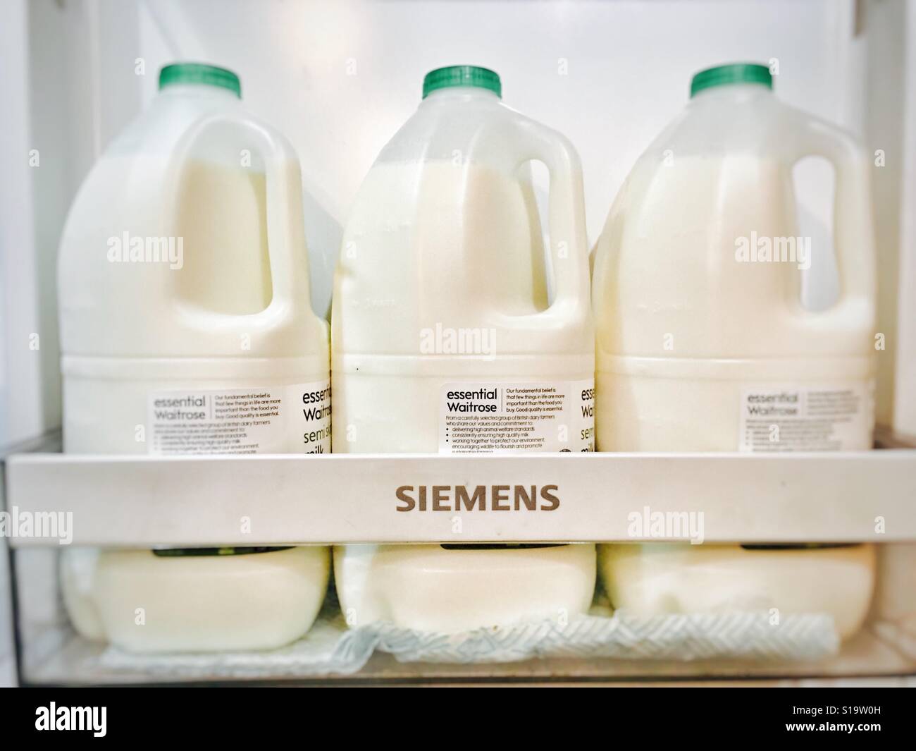 Waitrose essenziale il latte parzialmente scremato in frigo Foto Stock