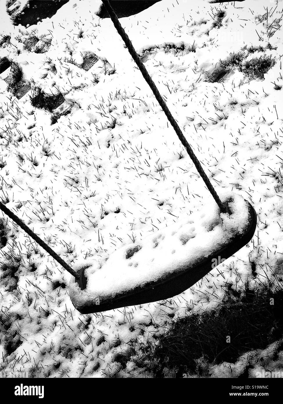 Bambino in oscillazione la neve su un giorno di inverno Foto Stock