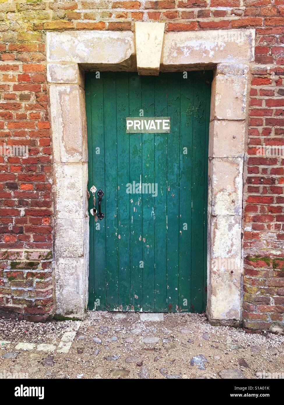 Segno privato su un blocco porta verde con architrave in pietra in un muro  di mattoni Foto stock - Alamy