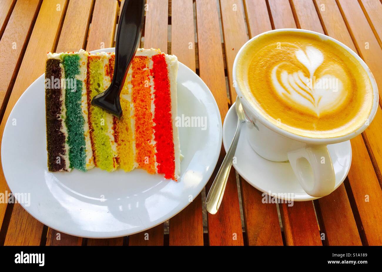 Rainbow torta e cappuccino con cuore decorativo fiore - Immagine stock catturata con smartphone