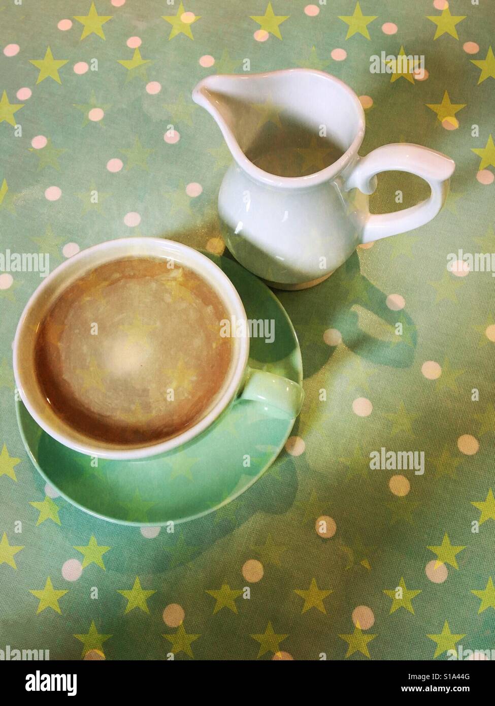 Il caffè nella tazza verde con piattino e Caraffa del Bianco su avvistato e sfondo stellato - Immagine stock catturata con smartphone