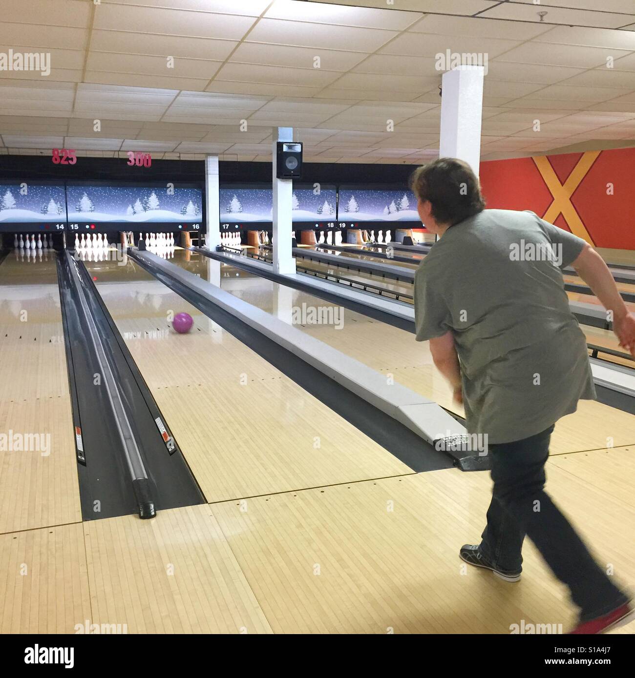 Una donna bocce in una pista da bowling - Immagine stock catturata con smartphone