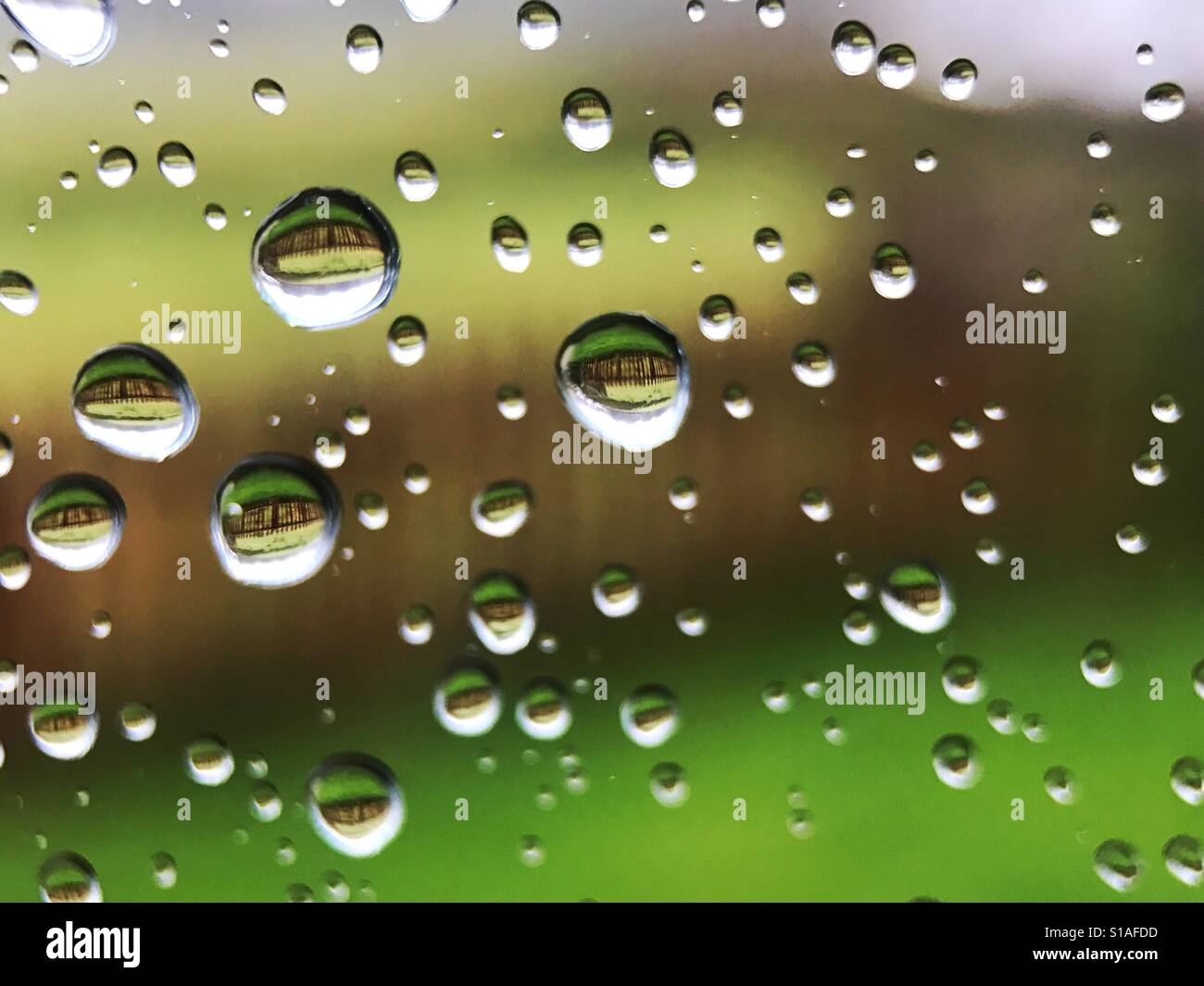 Gocce di pioggia sul vetro del finestrino Foto Stock