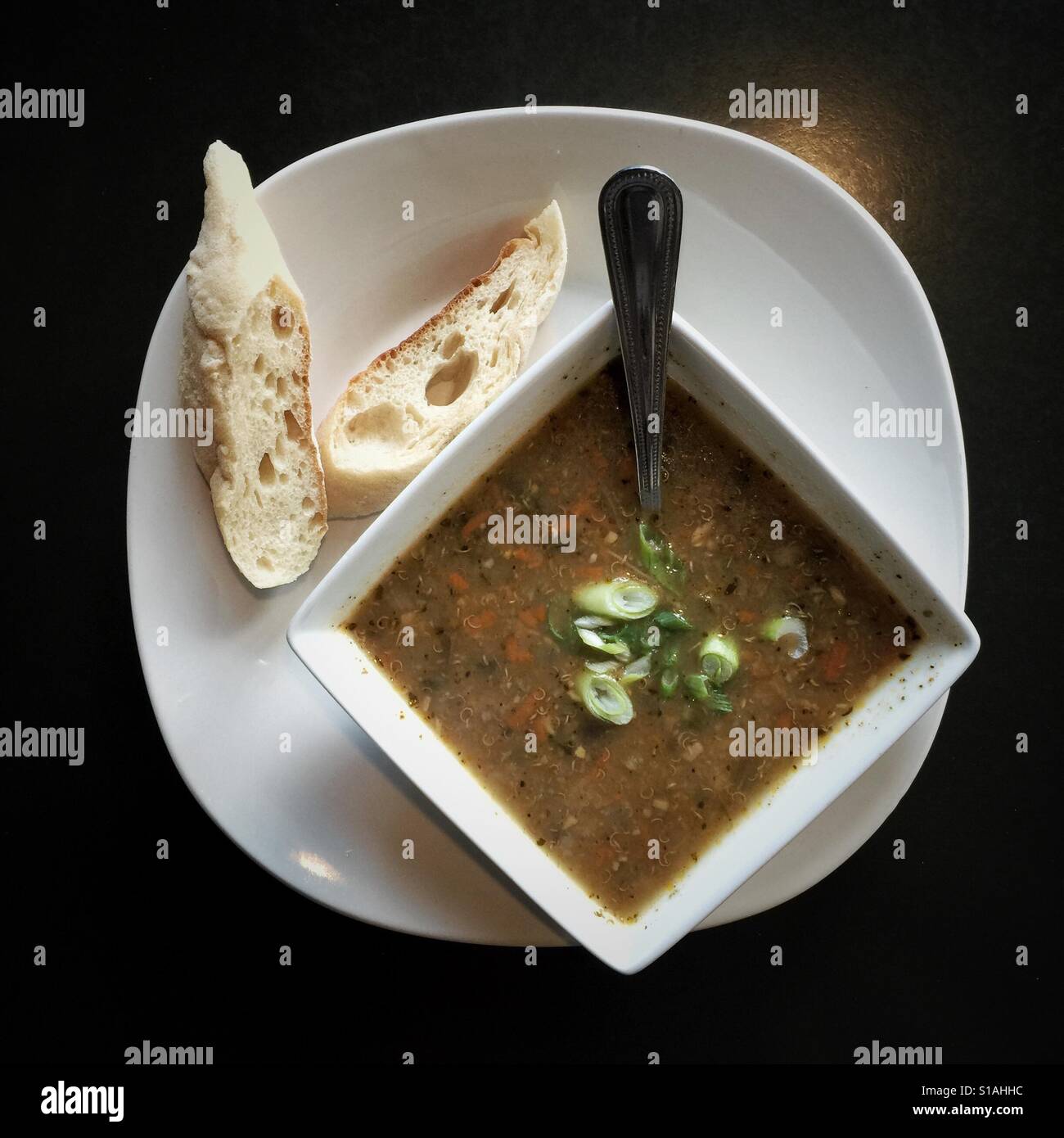 La vaschetta del vegan zuppa di lenticchie e pane sulla piastra bianca - Immagine stock catturata con smartphone