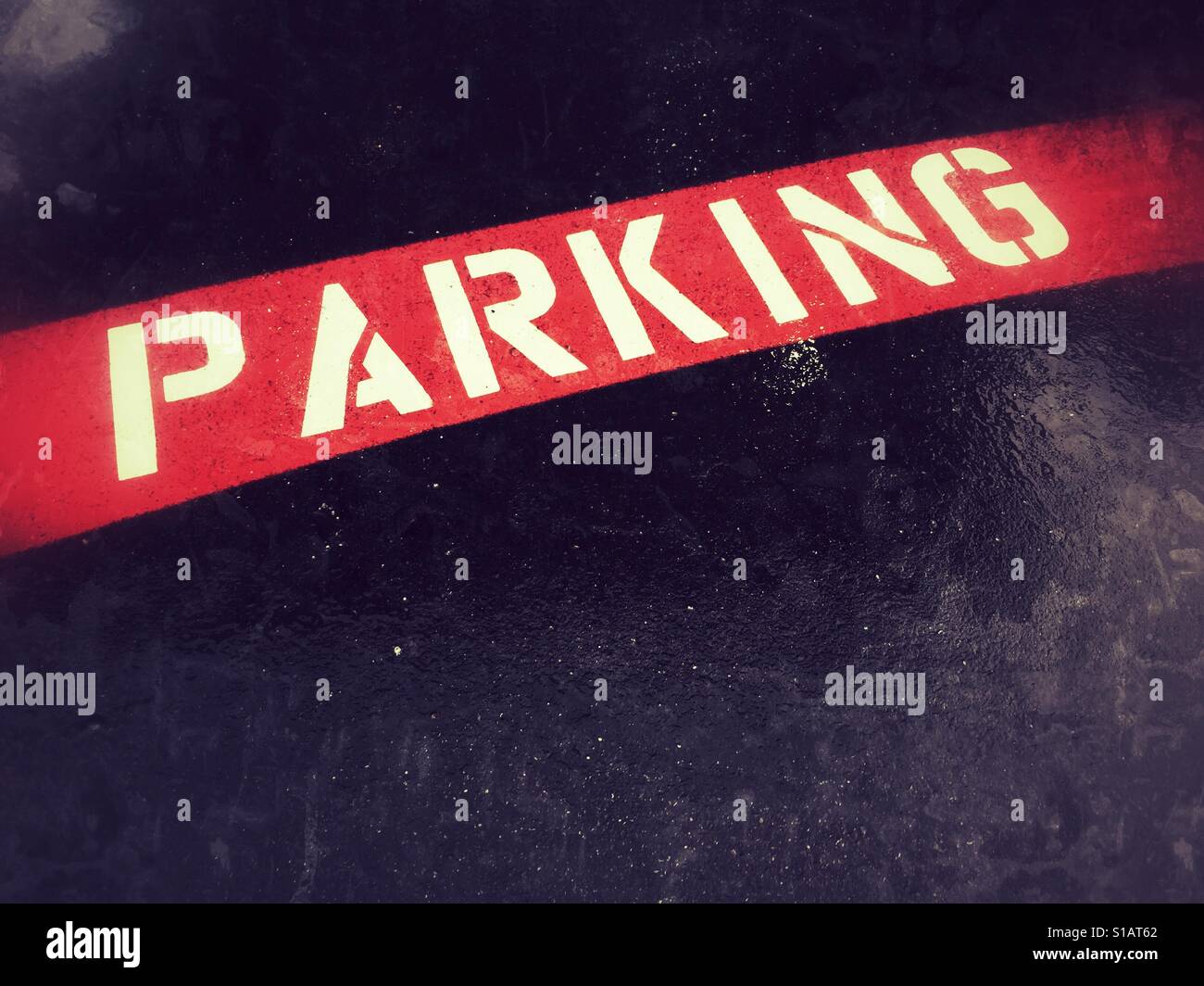 La parola 'parcheggio' stampata sulla striscia rossa sul marciapiede. Copyspace. - Immagine stock catturata con smartphone