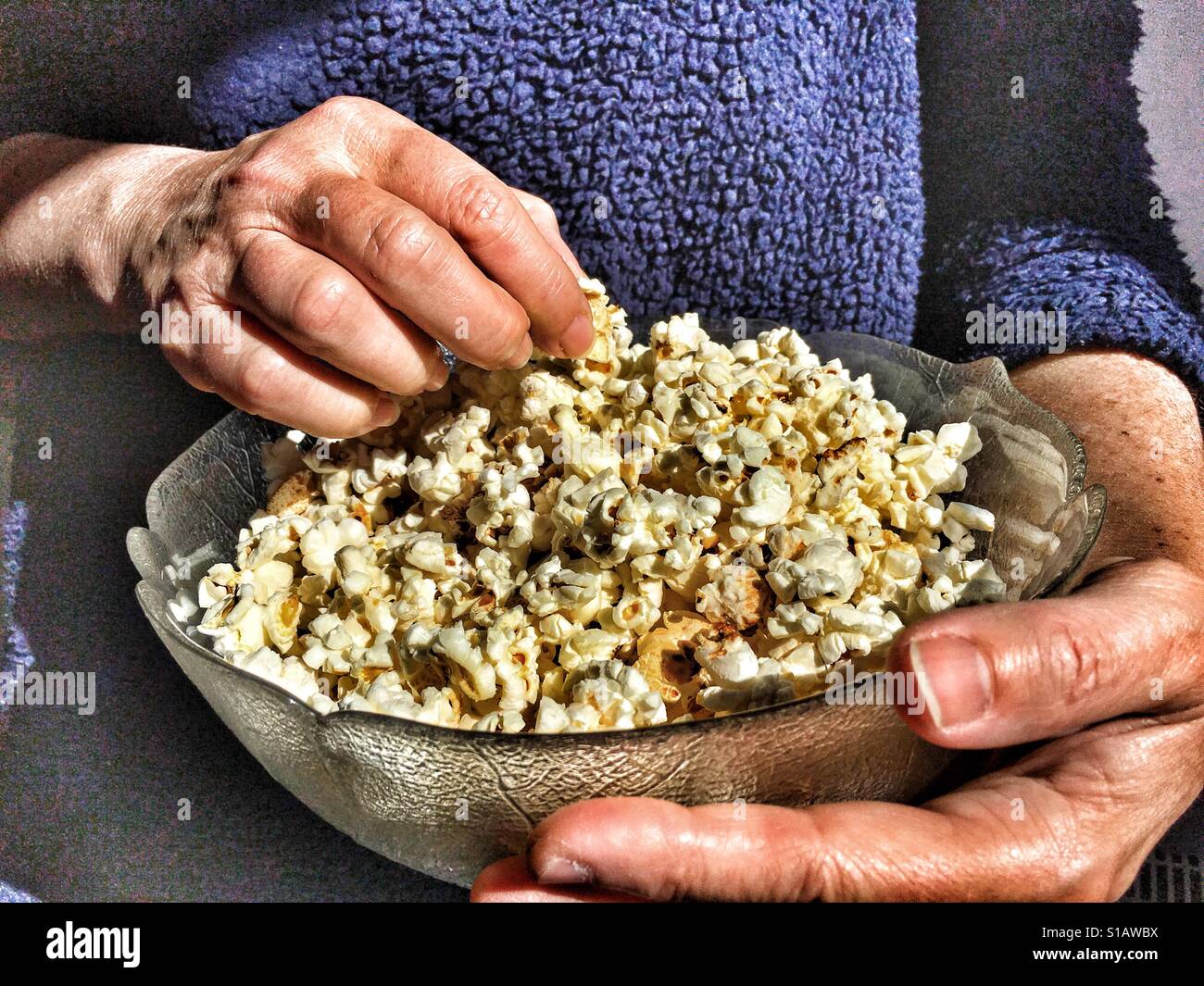 Donna che mantiene una ciotola di popcorn, close up delle mani Foto Stock