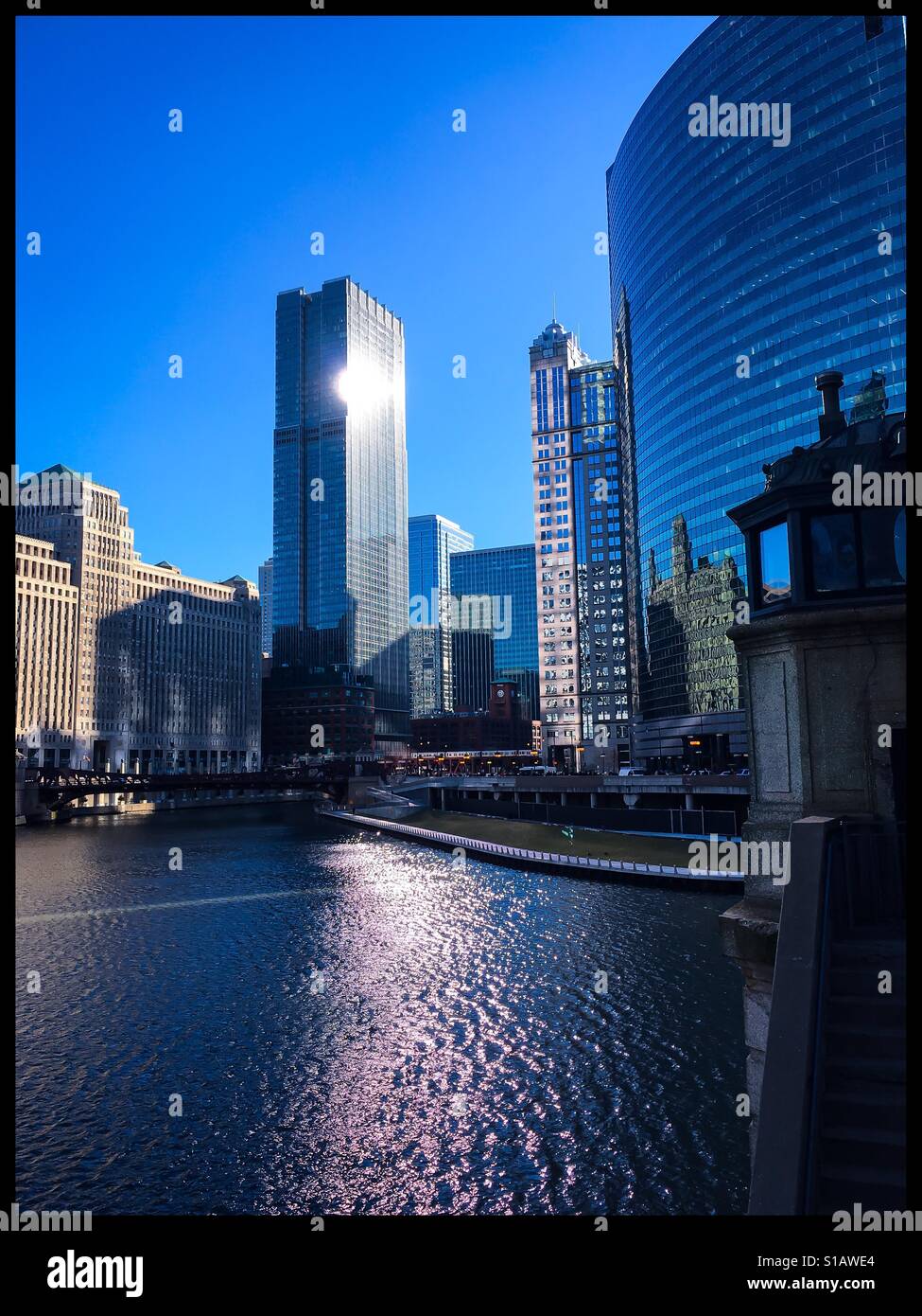Buongiorno, Chicago. Vista del tramonto riflesso di costruire sul fiume e lungo il Riverwalk da un ponte. Foto Stock