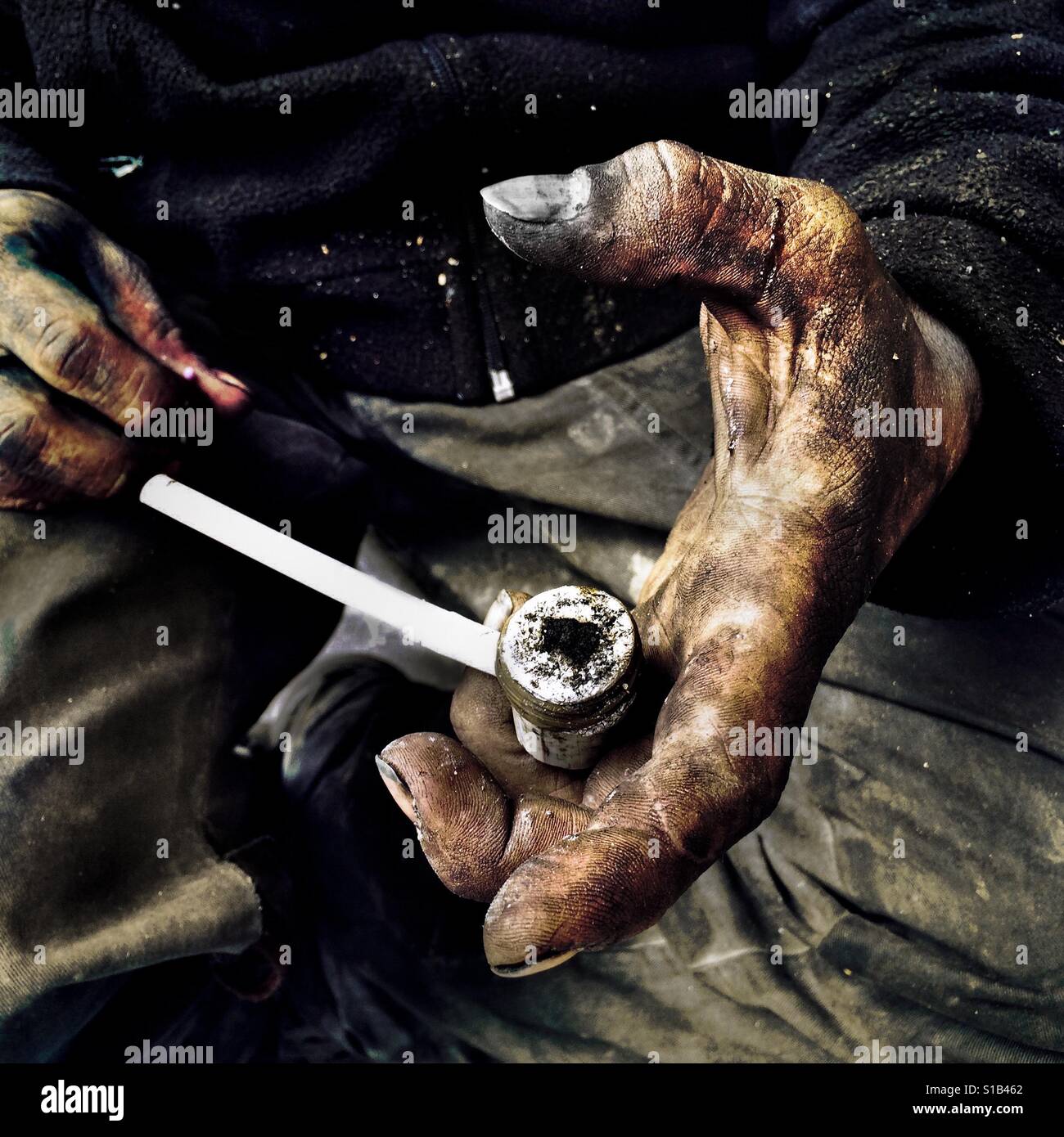 Un colombiano "basuco' fumatore, vivono per strada, mostra un tubo improvvisata caricato da materie cocaina pasta, a Bogotà, Colombia, il 15 febbraio 2016. Foto Stock