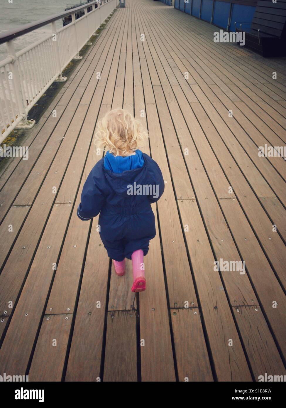 Bimbi giovane ragazza camminare lungo il legno Peir Bournemouth Foto Stock