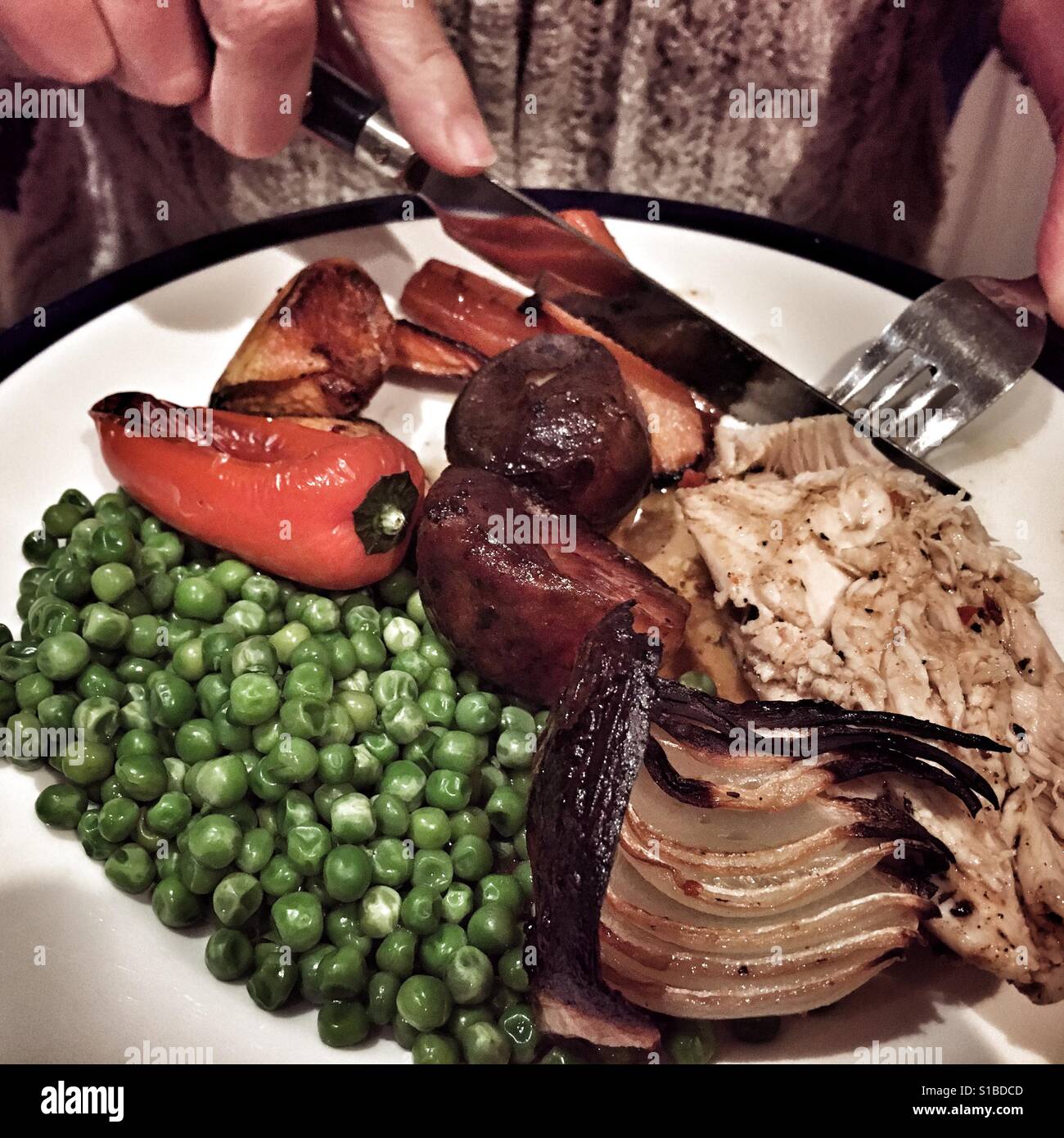 Coltello e forchetta in mano, a partire da un pollo arrosto cena Foto Stock