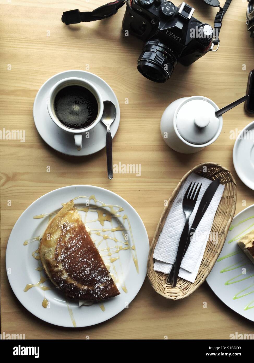 Caffè, pasticceria e fotocamera a pellicola su un tavolo nella caffetteria in Cusco, Perù Foto Stock