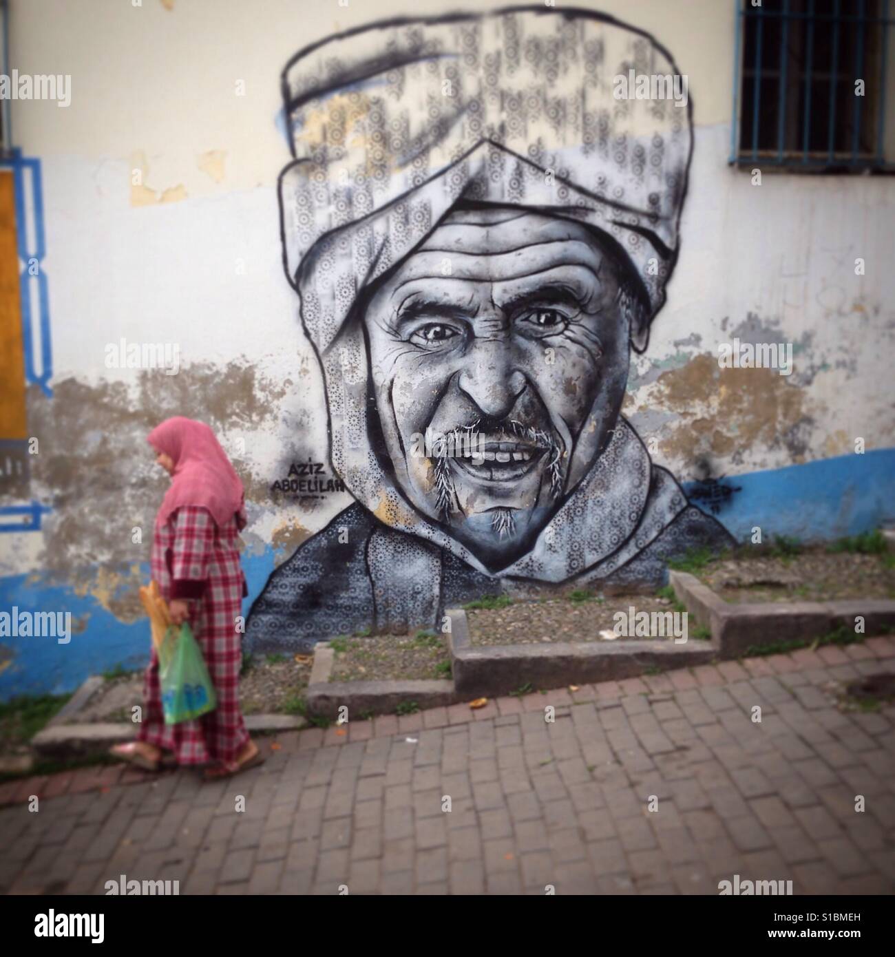 La donna in una strada da Tanger, Marocco, Africa. Una faccia il disegno in un lampione - Immagine stock catturata con smartphone