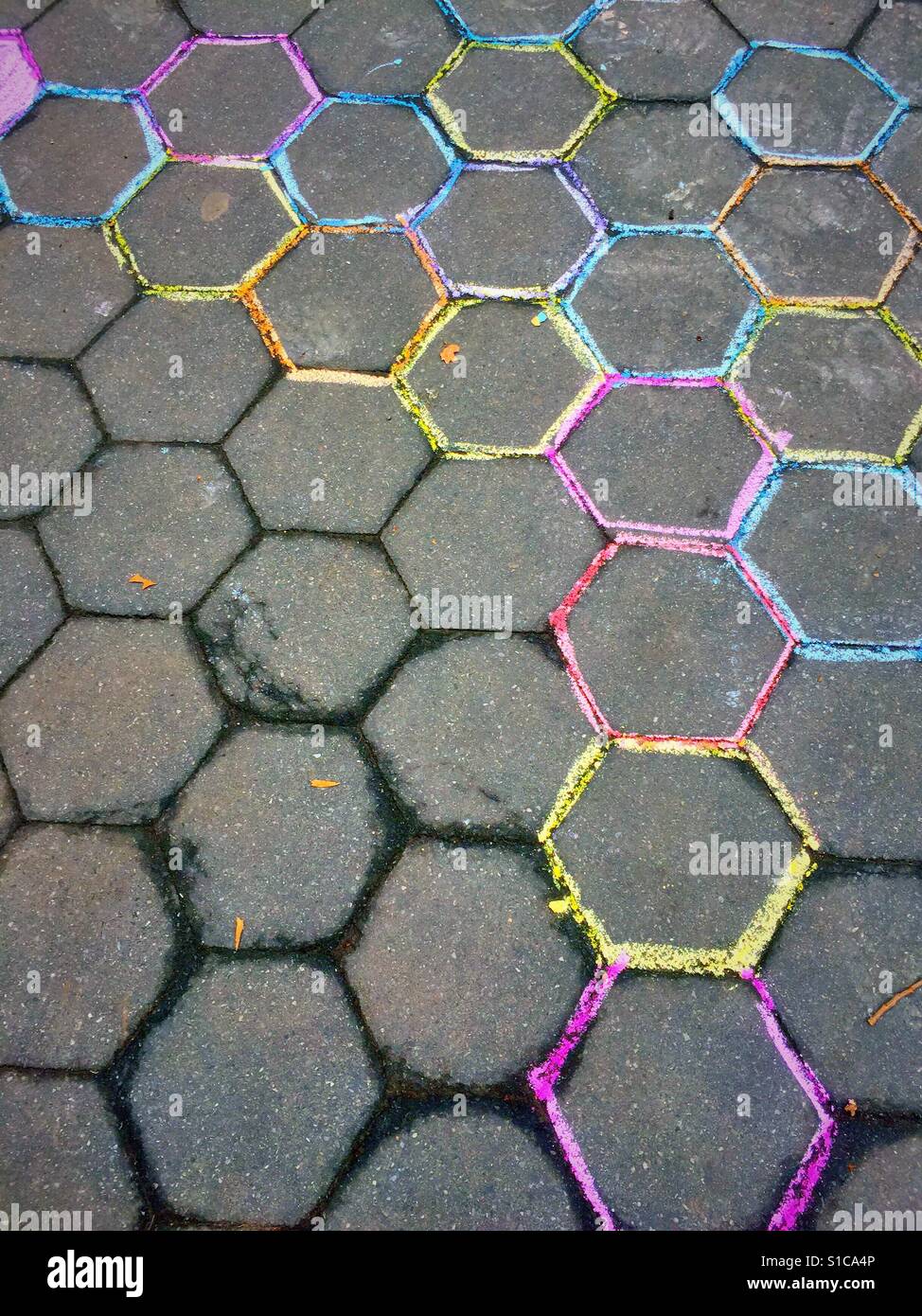 Il marciapiede con esagono pietre per pavimentazione delineata nel colorato chalk Foto Stock