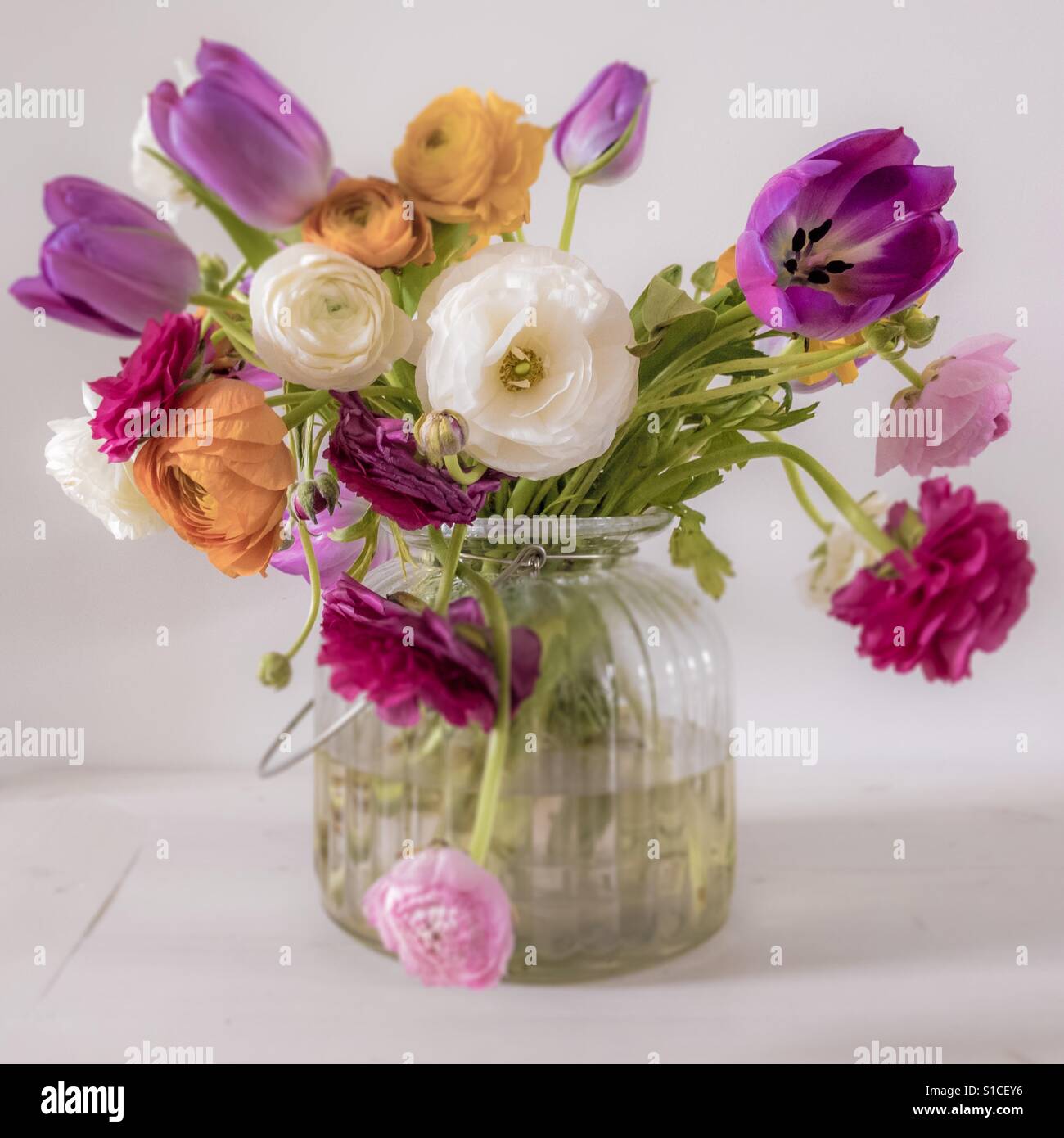 Fiori in vaso di vetro su bianco panca in legno - Immagine stock catturata con smartphone