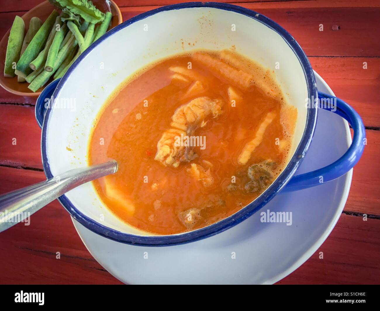 Pesce Barramundi in giallo aspro e la zuppa piccante Foto Stock